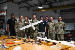 Group poses for a photo with a UAS.