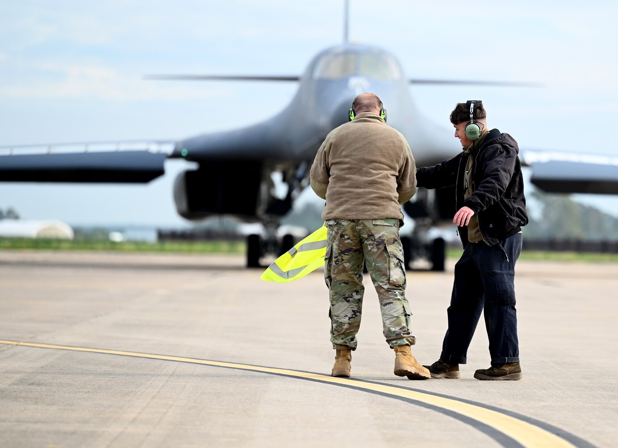 Airman 1st Class Andrew Graf, 9th Expeditionary Bomb Squadron crew chief, hands his reflective vest to Chief Master Sgt. Justin Daigle, 9th EBS Maintenance Senior Enlisted Leader, during Bomber Task Force 24-2 at Morón Air Base, Spain, April 2, 2024. Agile logistics and mobility activities, as showcased in operations and exercises, directly strengthen the U.S.’ ability to support Allies and partners and respond to potential crises. (U.S. Air Force photo by Staff Sgt. Holly Cook)
