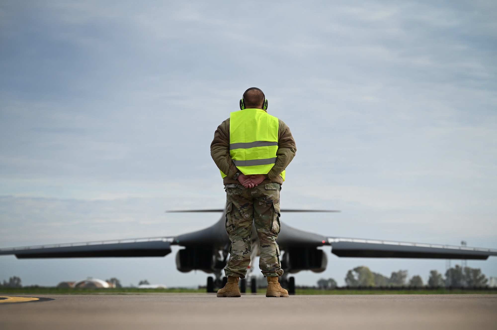 Chief Master Sgt. Justin Daigle, 9th Expeditionary Bomb Squadron Maintenance Senior Enlisted Leader, waits to marshall out a B-1B Lancer during Bomber Task Force 24-2 at Morón Air Base, Spain, April 2, 2024. BTF 24-2 is a part of LSGE 24, an umbrella term that incorporates dozens of separate exercises and military activities, under multiple combatant commands, that enable the U.S. Joint Force to train with Allies and partners and improve shared understanding, trust and interoperability on security challenges across the globe. (U.S. Air Force photo by Staff Sgt. Holly Cook)