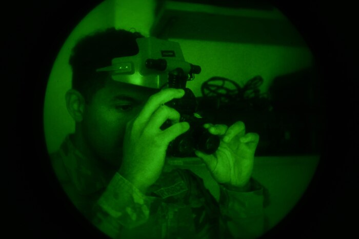 An Airman inspects night vision goggles.