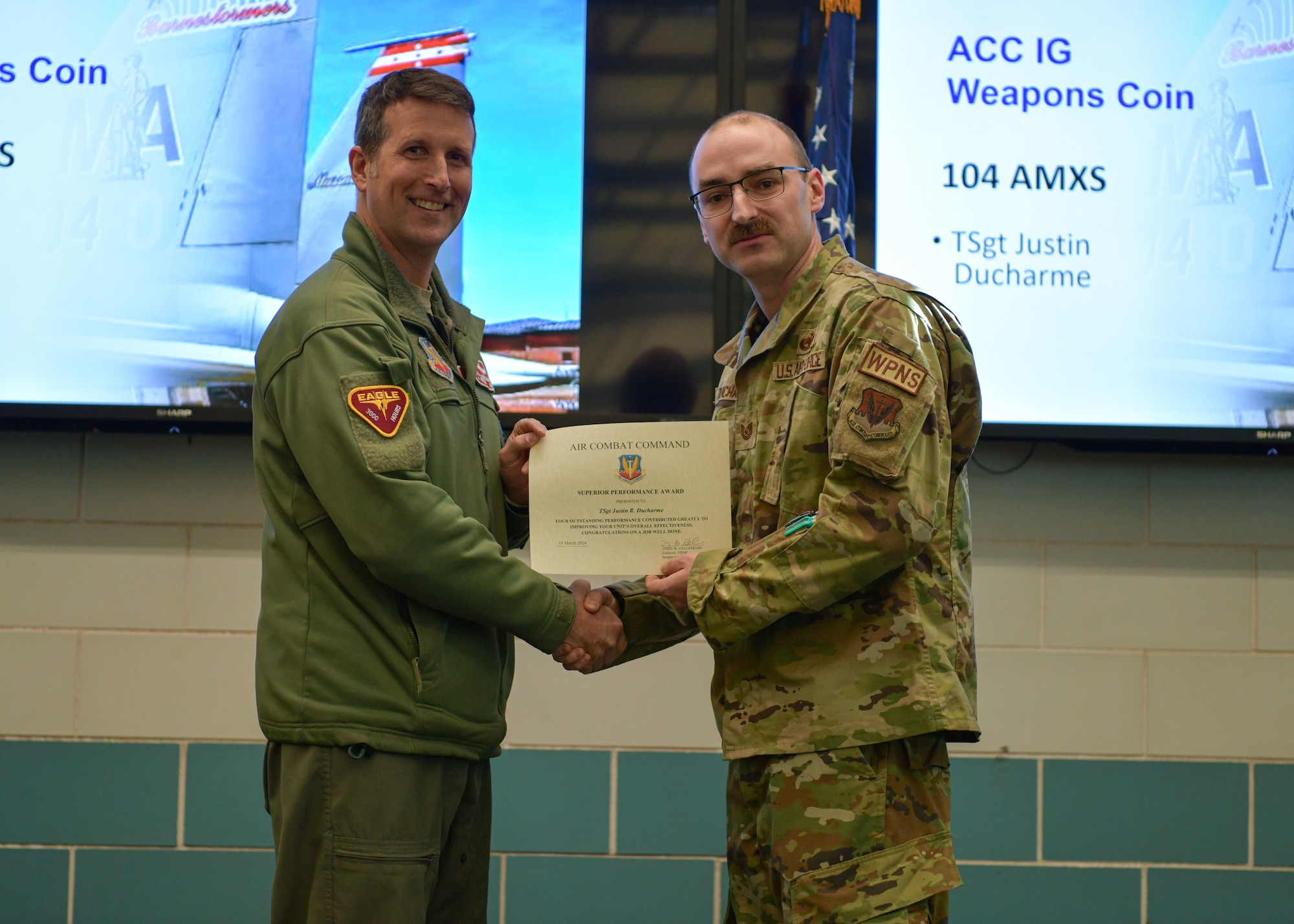Colonel David Halasi-Kun, 104th Fighter Wing commander, presents a superior performer award and Air Combat Command Inspector General weapons coin to Tech. Sgt. Justin Ducharme, 104th Maintenance Group armament systems technician, Thursday, March 21, 2024, at Barnes Air National Guard Base, Massachusetts. The 104th FW received 29 individual and 9 team recognitions and awards from the 2024 Unit Effectiveness Inspection for superior performance.