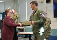 Colonel David Halasi-Kun, 104th Fighter Wing commander, presents superior performer award to Lisa Potitio, Barnes Wellness Team program manager, Thursday, March 21, 2024, at Barnes Air National Guard Base, Massachusetts. The 104th FW received 29 individual and 9 team  recognitions and awards from the 2024 unit effectiveness inspection for superior performance.