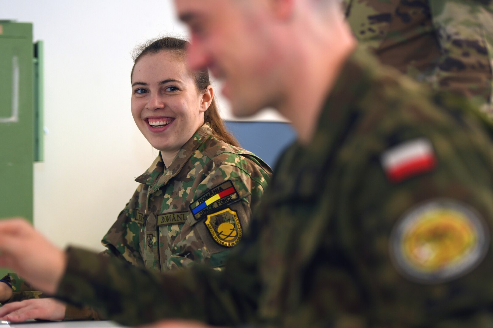 Army 2nd Lt. Emilia Patrulescu, a space operations officer with the Romanian Military Space and Radio Communications Agency, shares a laugh with Army 1st Lt. Norbert Cwalinski, a section chief with the Polish Armed Forces’ 22nd Military Cartographic Center, during the Joint Commercial Operations phase at Vulcan Guard Bolt 6, Ramstein Air Base, Germany, March 27, 2024. The space-focused exercise, now in its sixth iteration, is an Air National Guard-led event that seeks to integrate operations, intelligence and cyber personnel from across all seven Guard space states and NATO partners, incorporating several diverse space weapons systems in a realistic threat-based scenario.