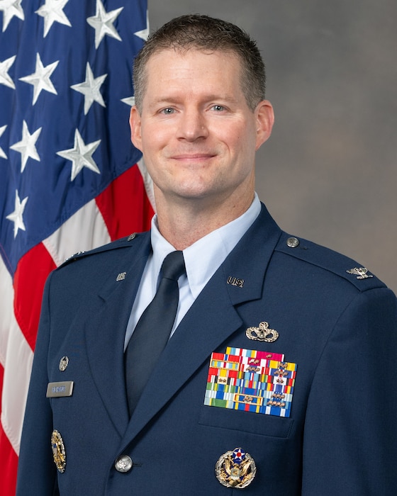 Official U.S. Air Force photo of Col Richards with American flag in the background.
