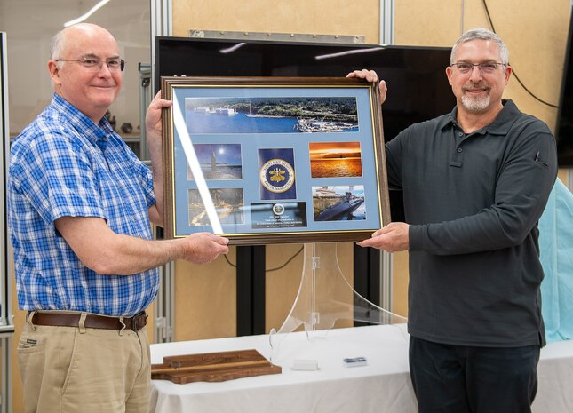 Bret Saddler (right) receives a command collage from Ed Ingles (left), during his retirement ceremony at TRFB.