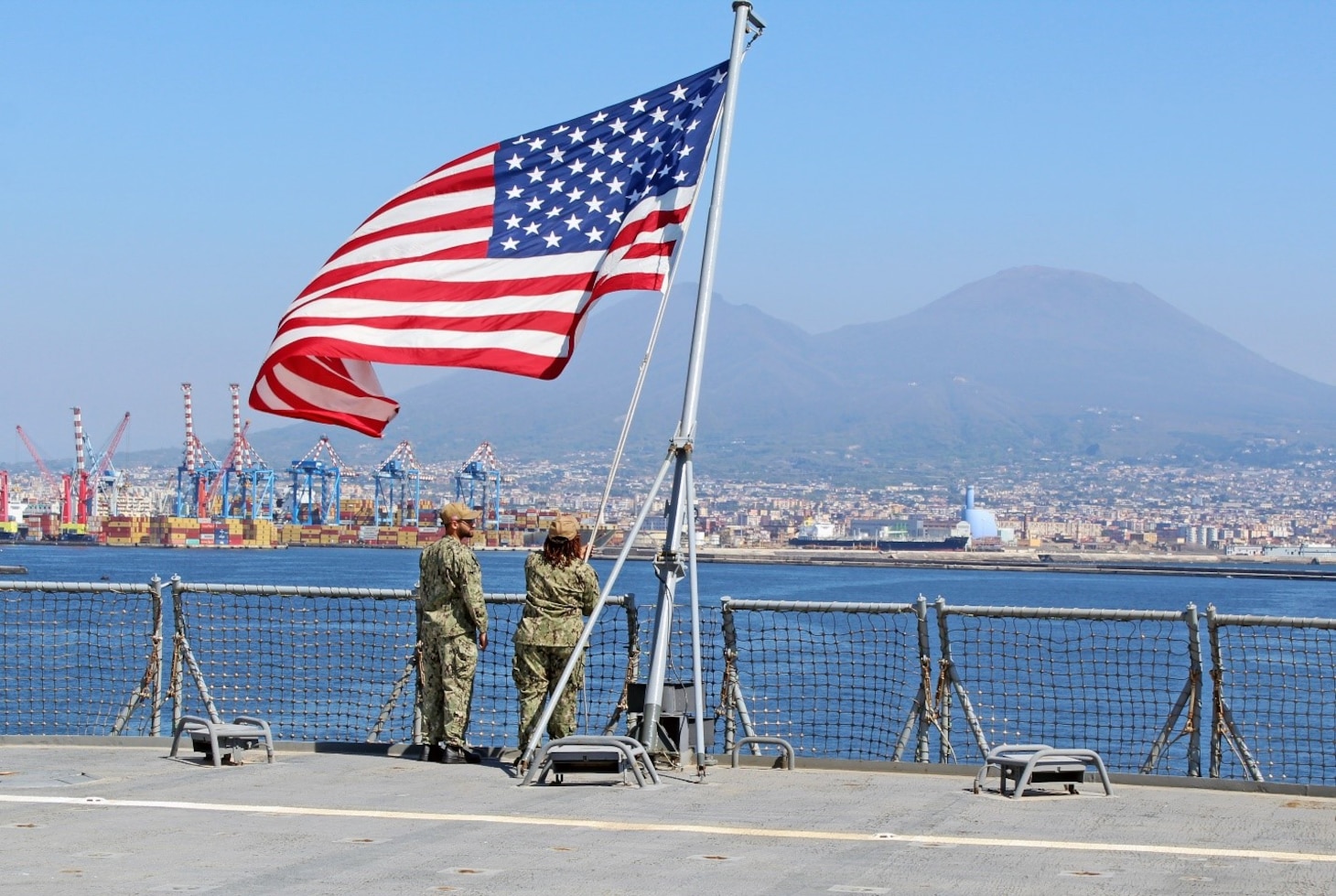 240407-N-JC445-1007 NAPLES, Italy (April 7, 2024) Electronics Technician 3rd Class Michael Thompson and Religious Program Specialist 1st Class Ashley Ferguson raise the Ensign during sea and anchor detail aboard the Blue Ridge-class command and control ship USS Mount Whitney (LCC 20) as it arrives in Naples, Italy. Mount Whitney, the U.S. Sixth Fleet flagship, is on a scheduled port visit to participate in the 75th anniversary of the NATO Alliance and enhance U.S.-Italian relations. Homeported in Gaeta, Mount Whitney operates with a combined crew of U.S. Sailors and Military Sealift Command civil service members. (U.S. Navy photo by Mass Communication Specialist 2nd Class Mario Coto)