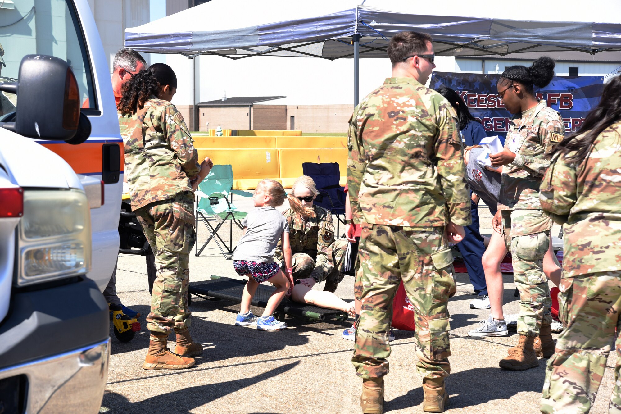 Military children "practice their medical skills" with medical personnel.