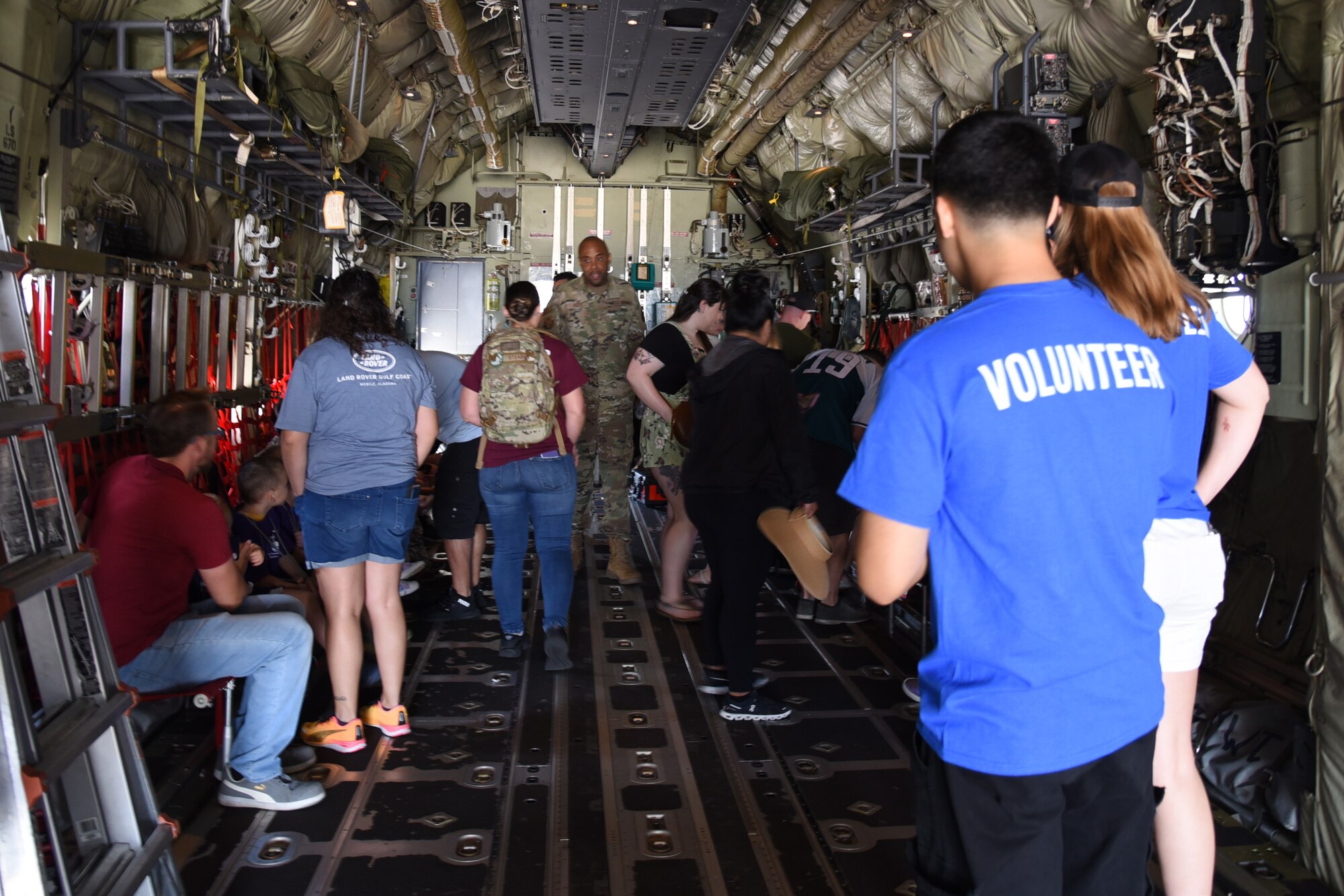 Military members and their families sit and belt into the C-130J Super Hercules static aircraft.