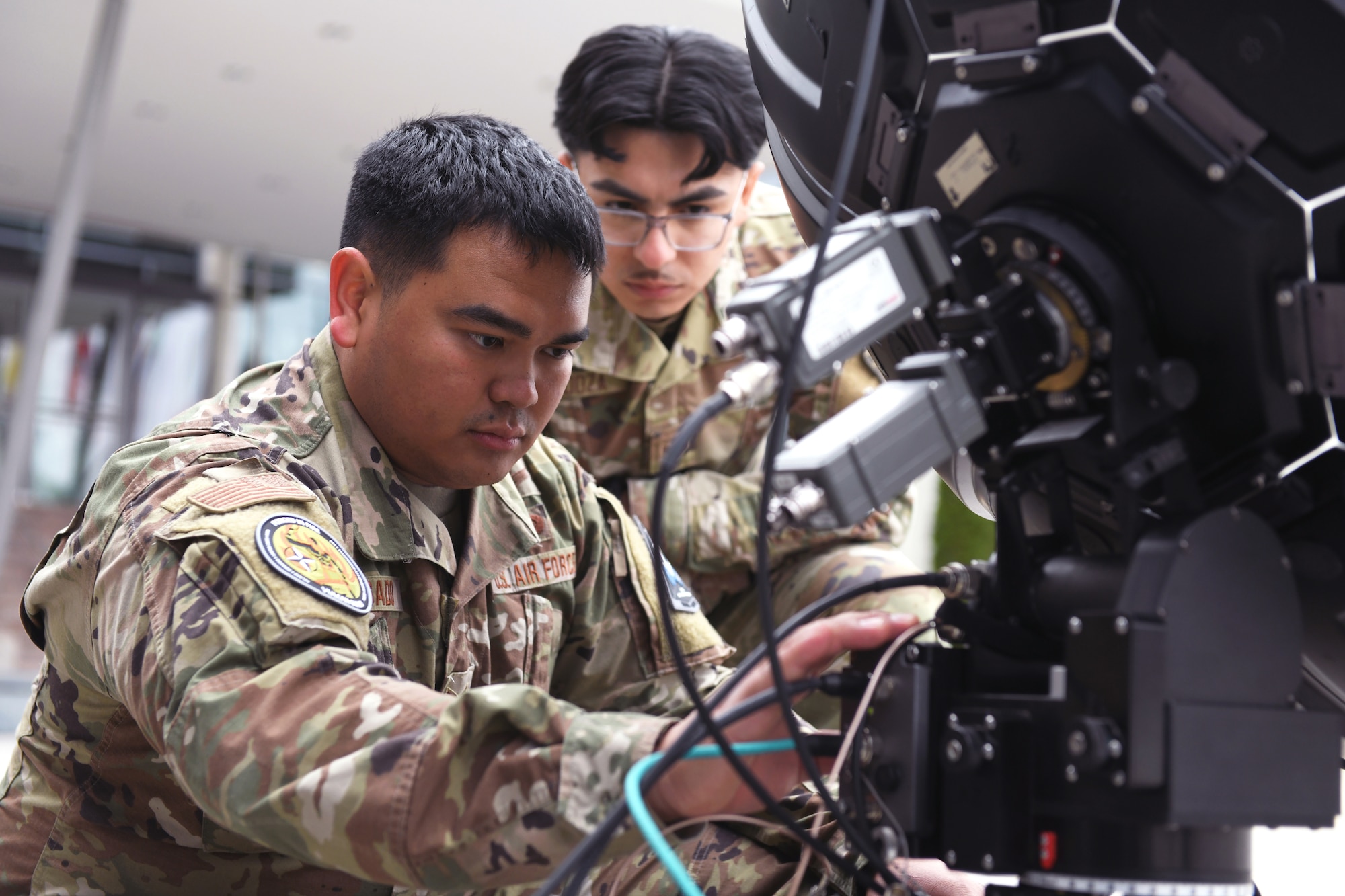 Air Force Staff Sgt. Javin Delgado, an electronic warfare specialist with the Hawaii Air National Guard’s 154th Wing, prepares to calibrate electronic warfare equipment as Senior Airman Oscar Mendoza, a space systems operator with the 148th Space Operations Squadron, looks on during Vulcan Guard Bolt 6, Ramstein Air Base, Germany, March 27, 2024. Though not part of the mission planning portion of the space-focused exercise, Delgado and Mendoza showcased EW assets to Vulcan Guard participants and distinguished visitors.