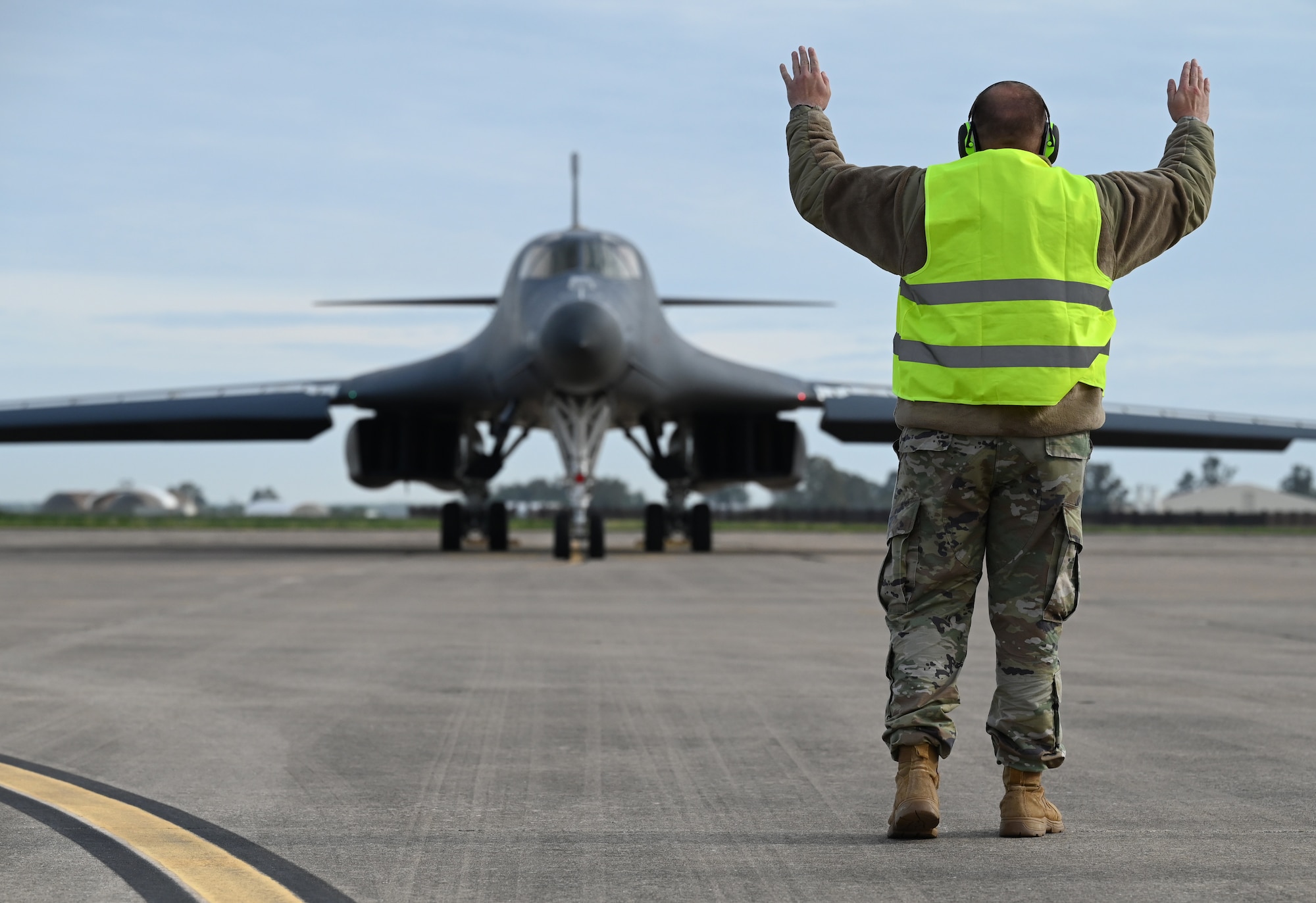 Chief Master Sgt. Justin Daigle, 9th Expeditionary Bomb Squadron Maintenance Senior Enlisted Leader, marshalls out a B-1B Lancer during Bomber Task Force 24-2 at Morón Air Base, Spain, April 2, 2024. Agile logistics and mobility activities, as showcased in operations and exercises, directly strengthen the U.S.’ ability to support Allies and partners and respond to potential crises. (U.S. Air Force photo by Staff Sgt. Holly Cook)