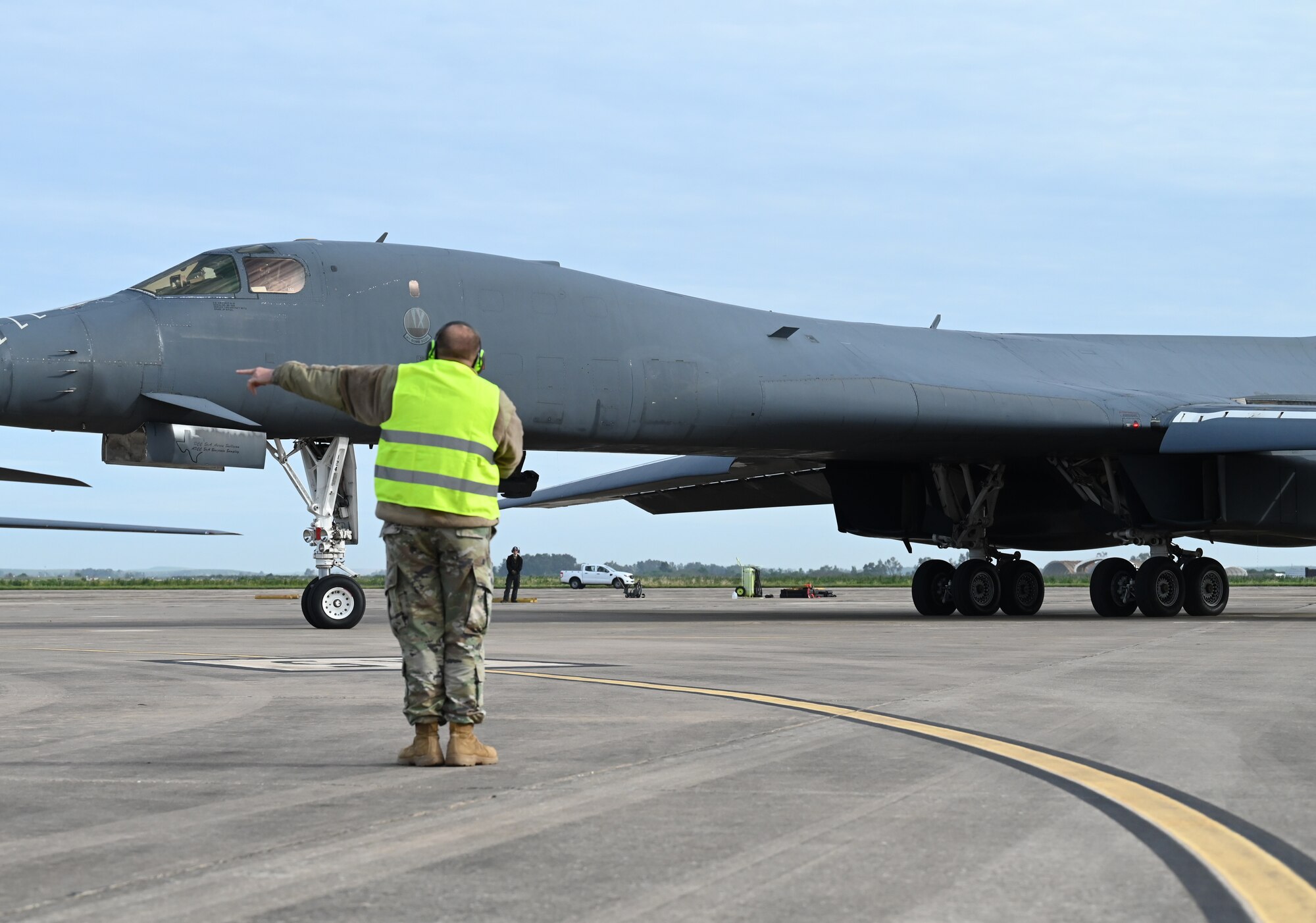 Chief Master Sgt. Justin Daigle, 9th Expeditionary Bomb Squadron Maintenance Senior Enlisted Leader, marshalls out a B-1B Lancer during Bomber Task Force 24-2 at Morón Air Base, Spain, April 2, 2024. The rotational deployment of U.S. bomber forces in Europe is evidence of the enduring commitment to NATO Allies and to a whole, free and peaceful Europe. U.S. forces are ready, postured and well-prepared to integrate with host-nation Allies and partners to deter threats and defend the Alliance. (U.S. Air Force photo by Staff Sgt. Holly Cook)