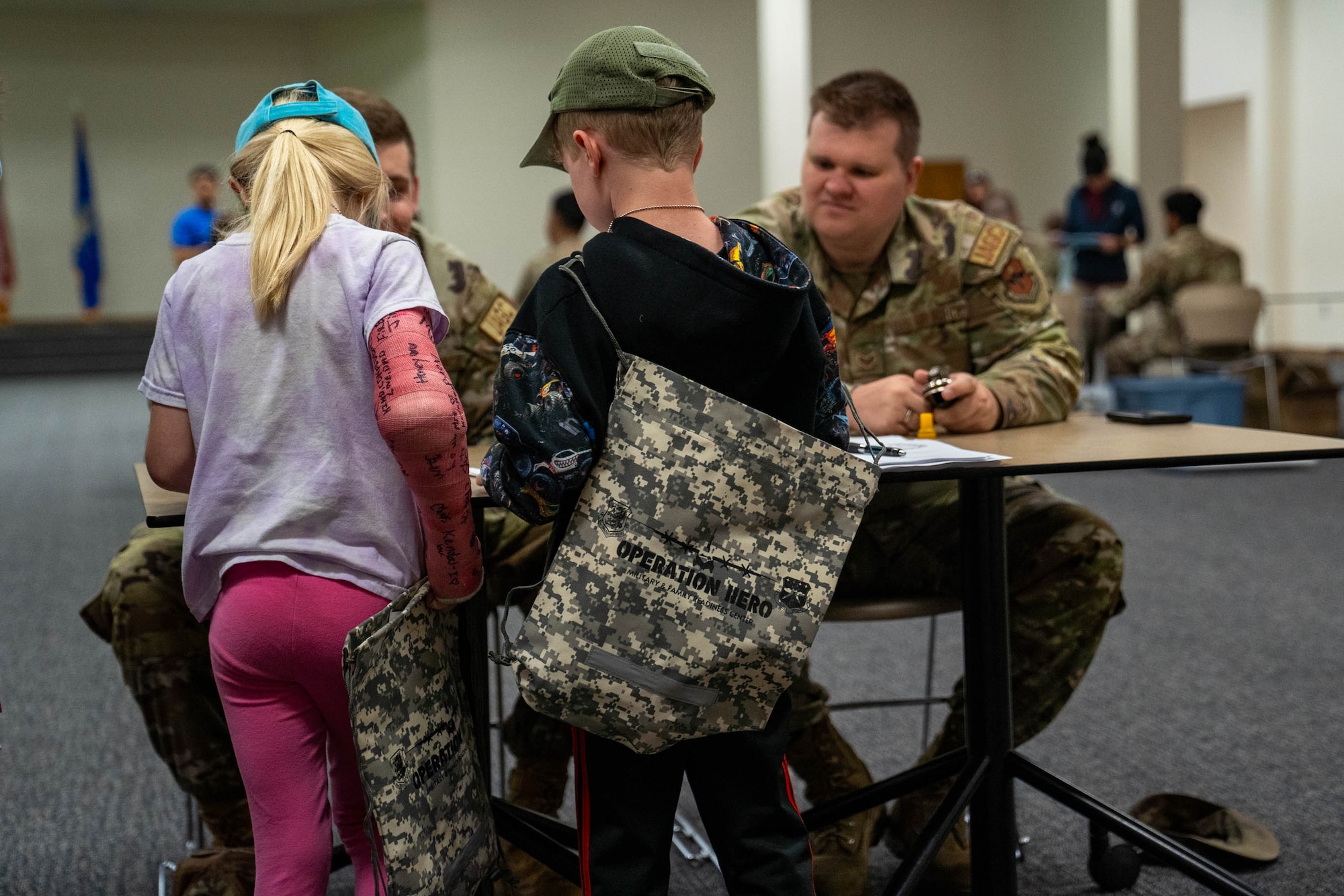 Military children listen to a simulated deployment briefing from members of the 81st Training Wing judge advocate general corps during Operation HERO at Keesler Air Force Base, Mississippi, April 6, 2024.