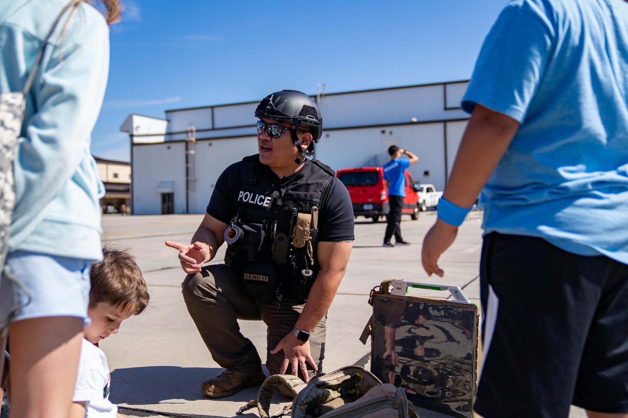 Sgt. Jeff Langlinais, Biloxi Bomb Squad public safety bomb technician, simulates inspecting a suspicious package with military children at Operation HERO at Keesler Air Force Base, Mississippi, April 6, 2024.