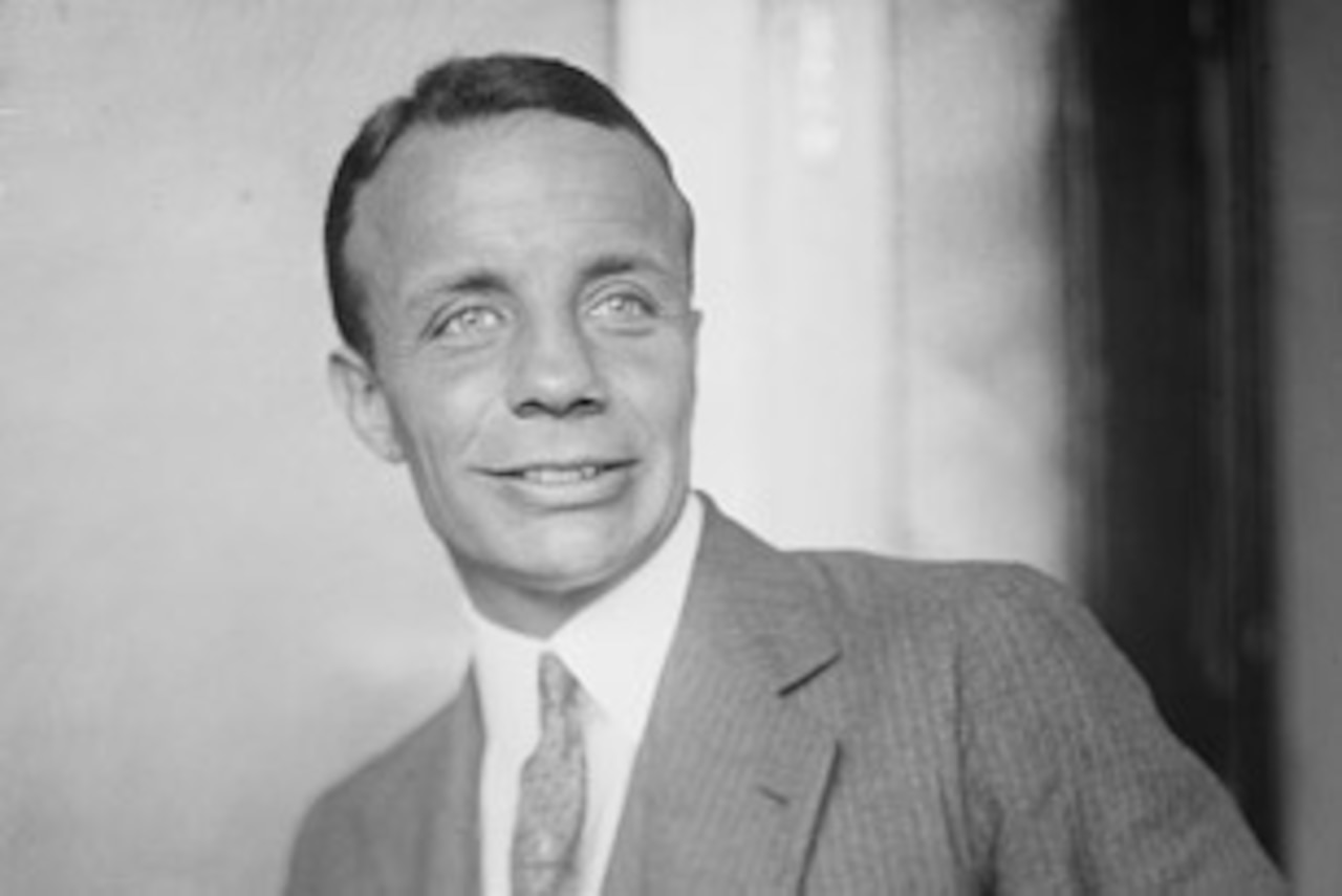 A black-and-white headshot of a person in a suit.