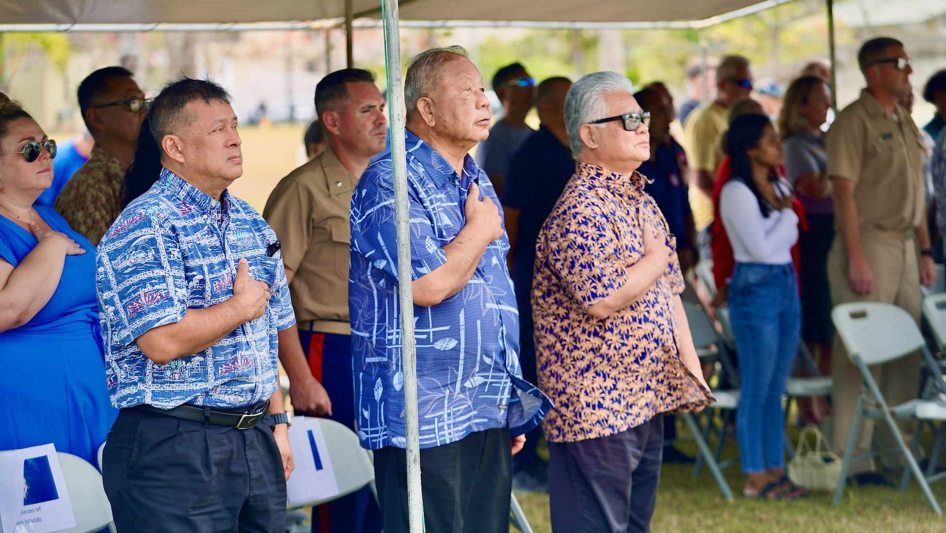 Assembled leaders of the Northern Mariana Islands stand for the national anthem and CNMI song at a ceremony to formally establish MSU Saipan in Garapan at the American Memorial Park on April 5, 2024. This significant achievement marks a milestone in leadership evolution and responsibility expansion within the U.S. Coast Guard, reflecting steadfast commitment to serving the people of Saipan and the Commonwealth of the Northern Marianas Islands (CNMI) with unparalleled dedication and excellence. The change is part of an initiative to provide junior officers with increased command opportunities, fostering professional growth and leadership development within the ranks. Eighteen marine safety detachments are converting to marine safety units. (U.S. Coast Guard photo by Chief Warrant Officer Sara Muir)