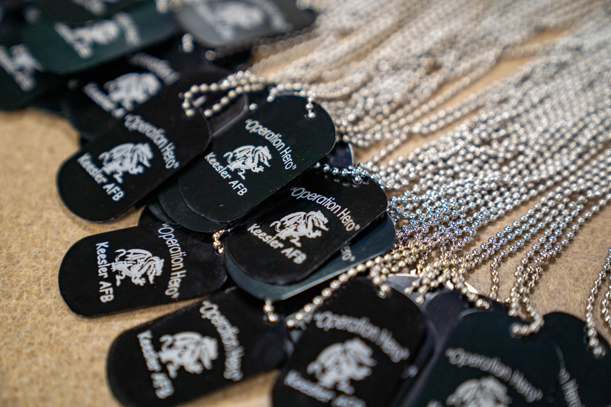 Operation HERO dog tags are laid out for military children at Keesler Air Force Base, Mississippi, April 6, 2024.