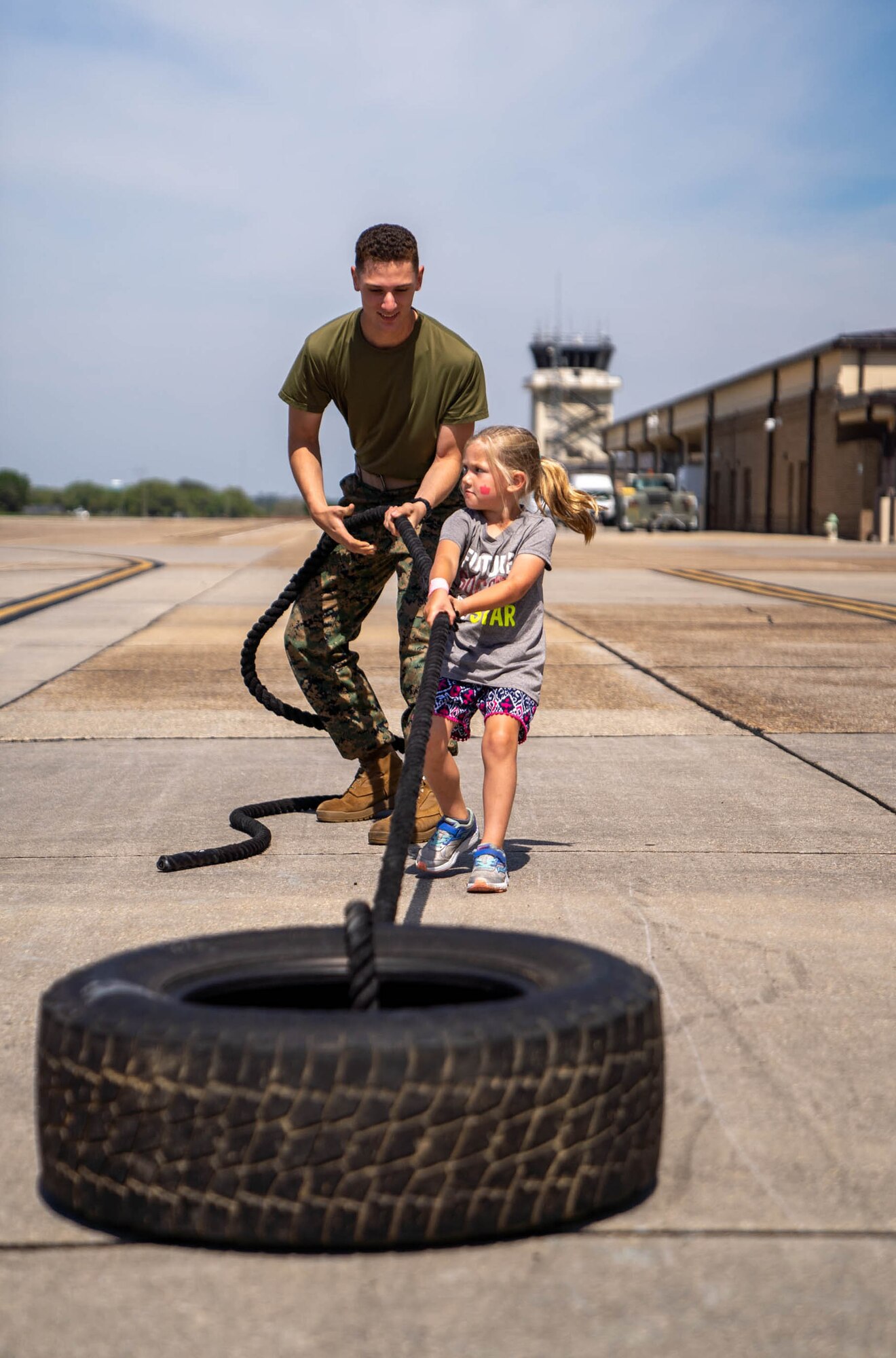 A student in the Keesler Marine Detachment helps a military child complete a tire drag at Operation HERO at Keesler Air Force Base, Mississippi, April 6, 2024.