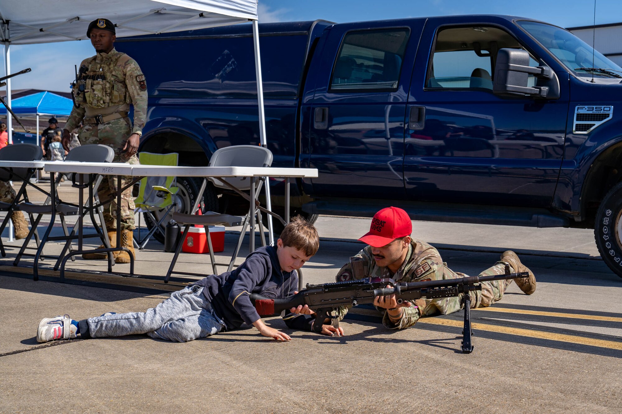 U.S. Air Force Senior Airman Henesis Falcon, 81st Security Forces Squadron combat arms instructor, shows a military child parts of a weapon during Operation HERO at Keesler Air Force Base, Mississippi, April 6, 2024.
