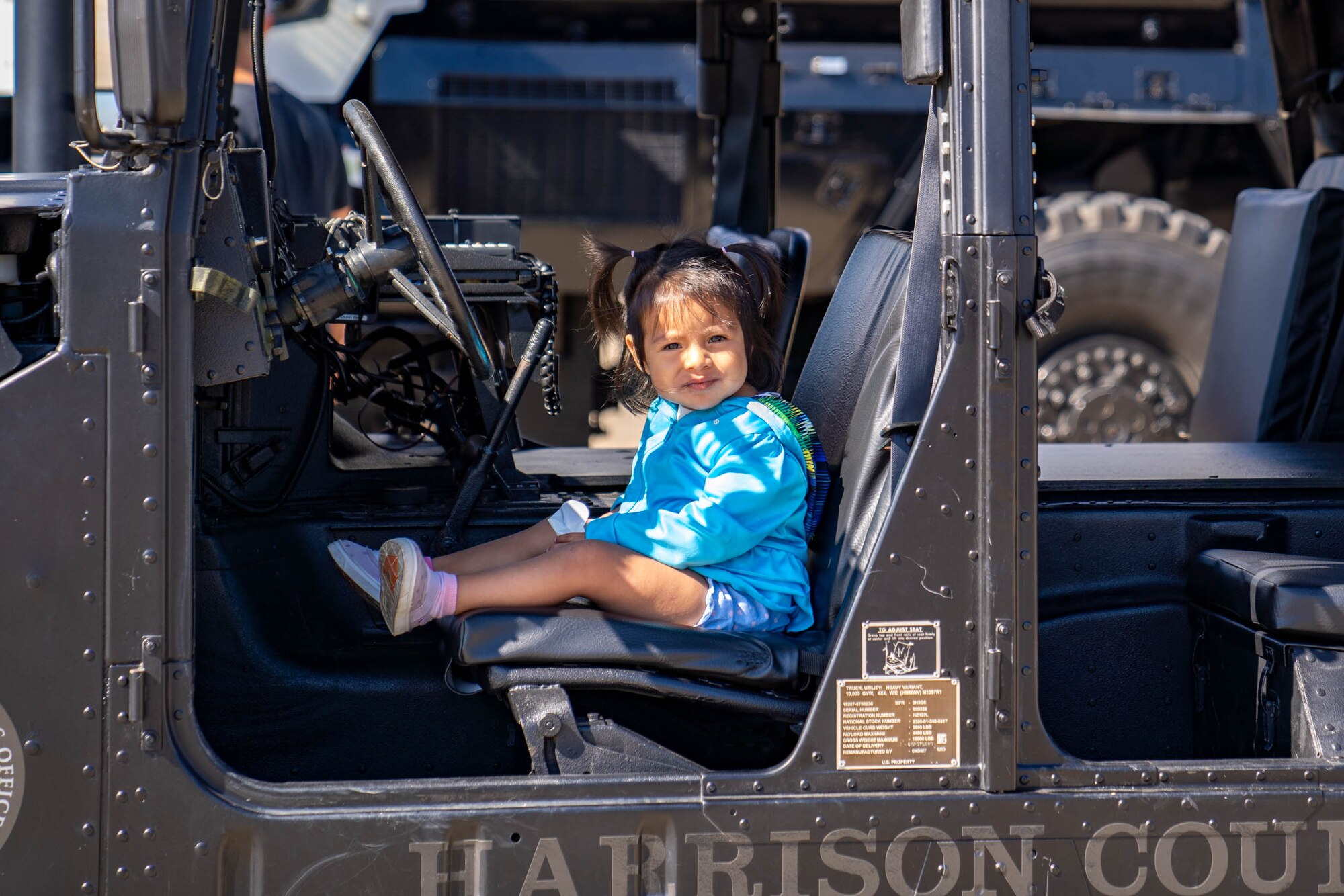 A military child explores a Harrison County police vehicle during Operation HERO at Keesler Air Force Base, Mississippi, April 6, 2024.