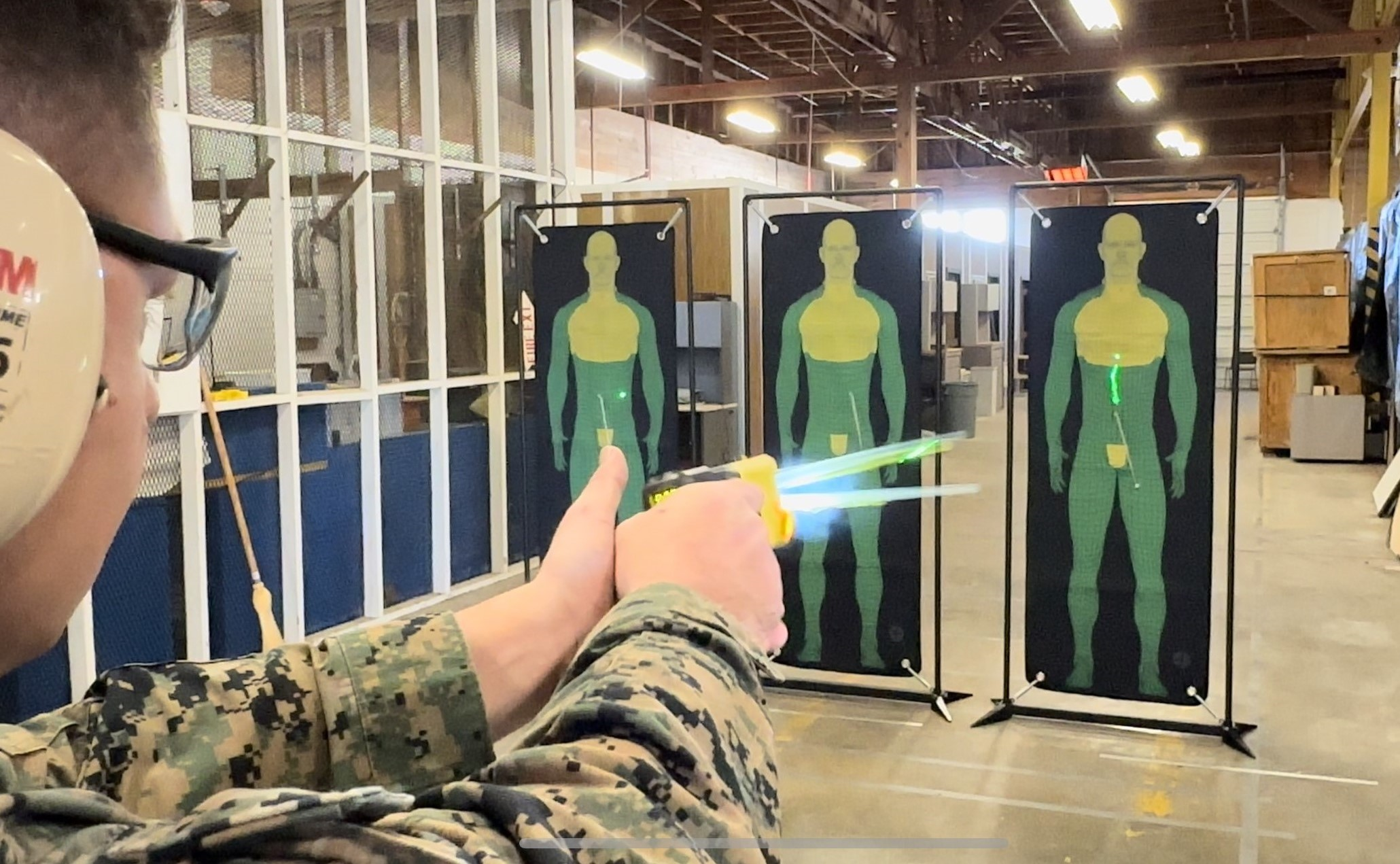 Gunnery Sgt. Robert Votta from the Inter-service Non-lethal Individual Weapons Instructor Course fires a next-generation human electro-muscular incapacitation device at a target during a limited user evaluation hosted by Air Force Security Forces Center. (Photo courtesy Joint Intermediate Force Capability Office)