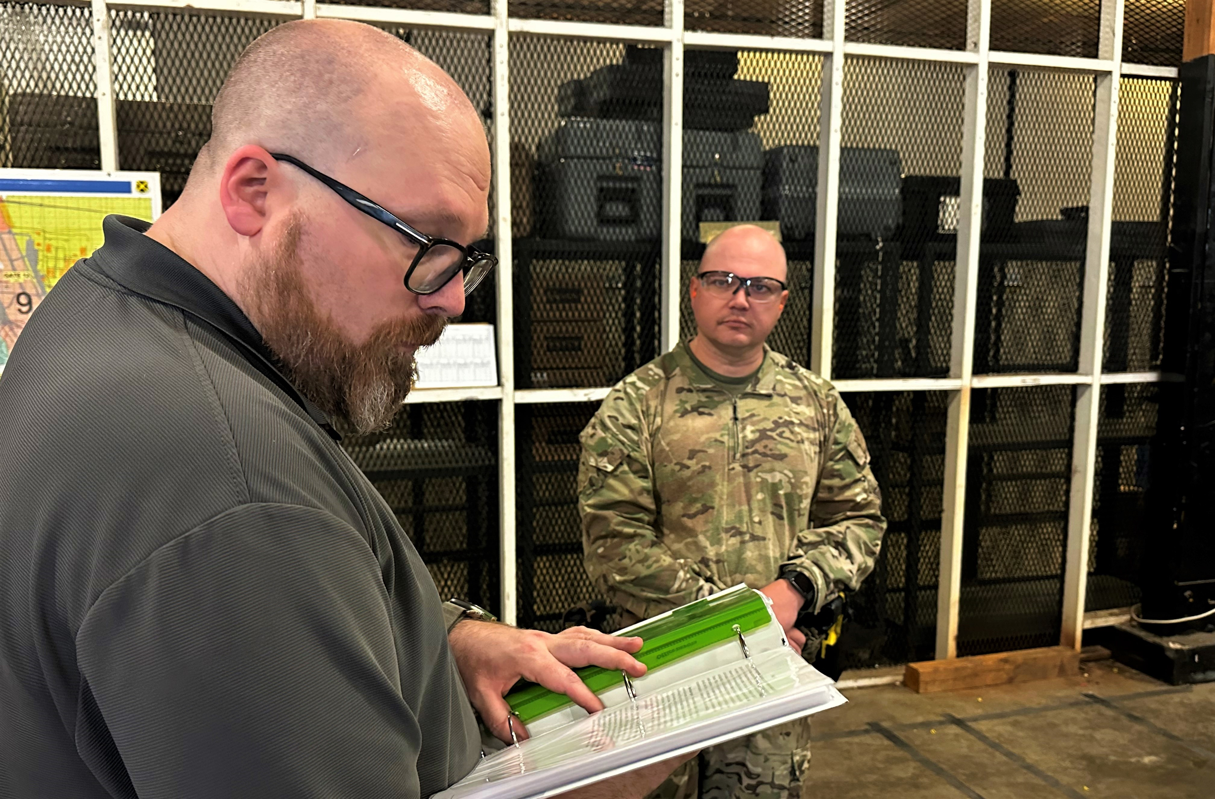 Aaron Hodges, Air Force Non-Lethal Weapons Acquisition Program support officer, reads an operational vignette to U.S. Coast Guard Lt. David Kveton prior to completing a live-fire evaluation of next-generation human electro-muscular incapacitation devices. (Photo courtesy Joint Intermediate Force Capabilities Office)
