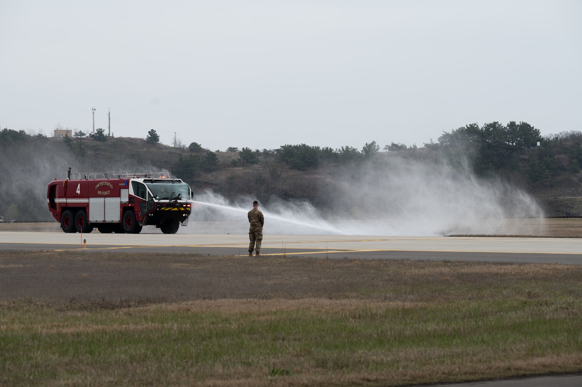 A firetruck sprays water onto concrete.