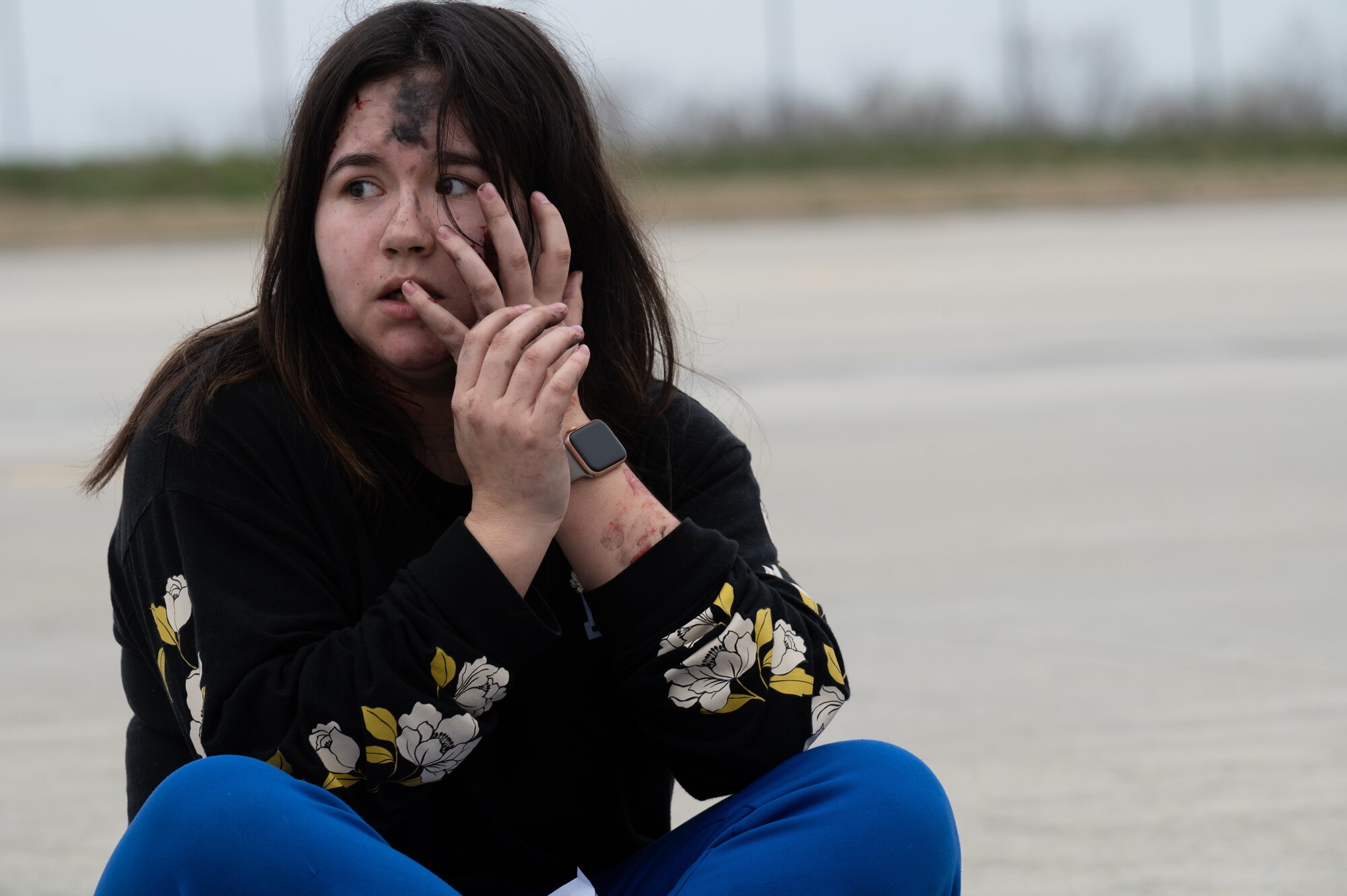 A female sits on the ground during an exercise.