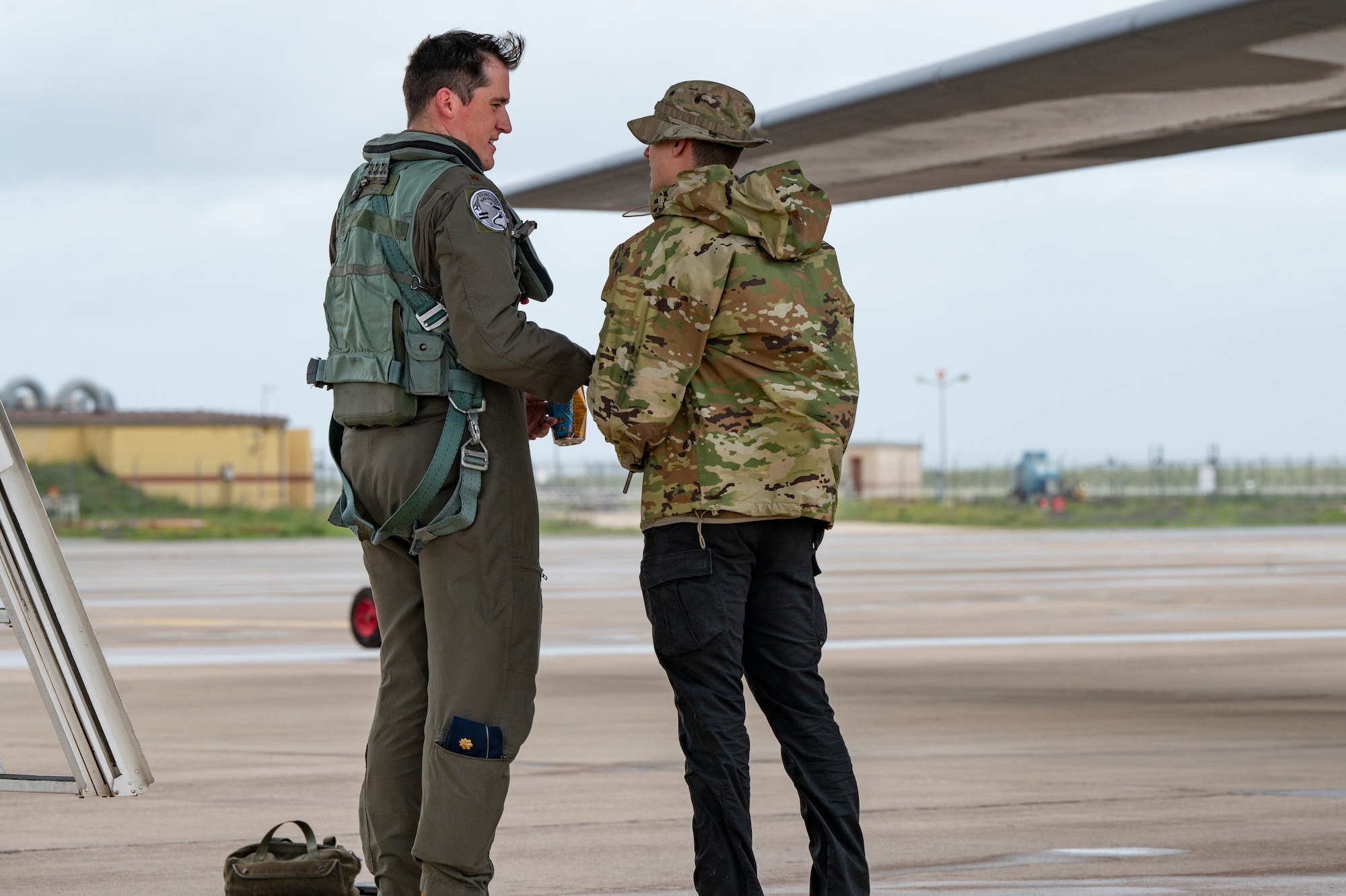 U.S. Air Force Maj. Stephen Carey, 9th Expeditionary Bomb Squadron Pilot, talks with Airman 1st Class Caden Egan, 9th EBS crew chief at Morón Air Base, Spain, during Bomber Task Force Europe, March 28, 2024. BTF missions familiarize aircrew with air bases and operations in different geographic areas of operation. (U.S. Air Force Photo by Airman 1st Class Emma Anderson)