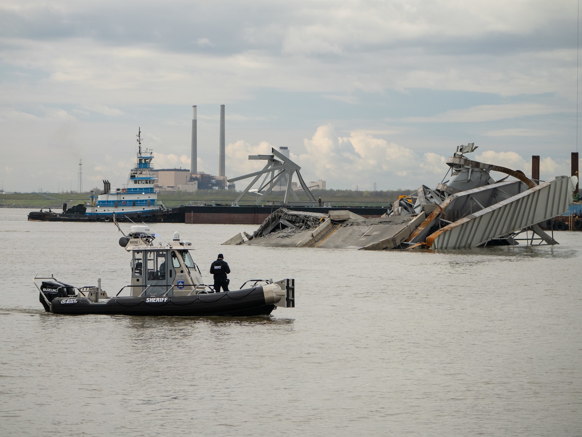 A portion of the collapsed Francis Scott Key Bridge truss is transported by barge to a disposal site.