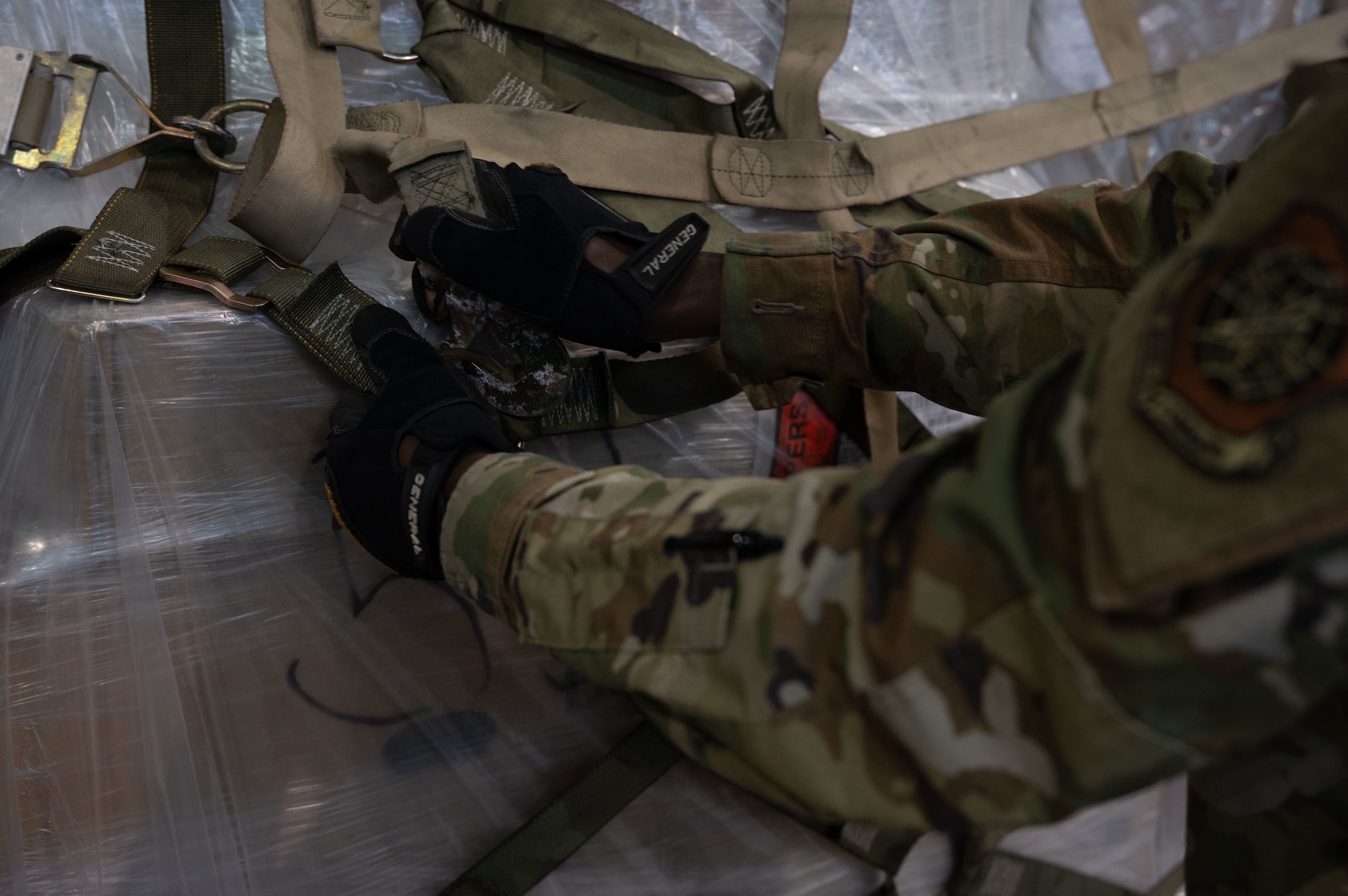 U.S. Air Force Airman 1st Class Kossivi Ayedji, 436th Aerial Port Squadron cargo processing specialist, secures a strap onto cargo at Dover Air Force Base, Delaware, April 4, 2024. The 436th APS, known as Dover AFB’s “Super Port,” has played a pivotal role in the base’s ongoing mission of rapid global mobility. (U.S. Air Force photo by Airman 1st Class Dieondiere Jefferies)