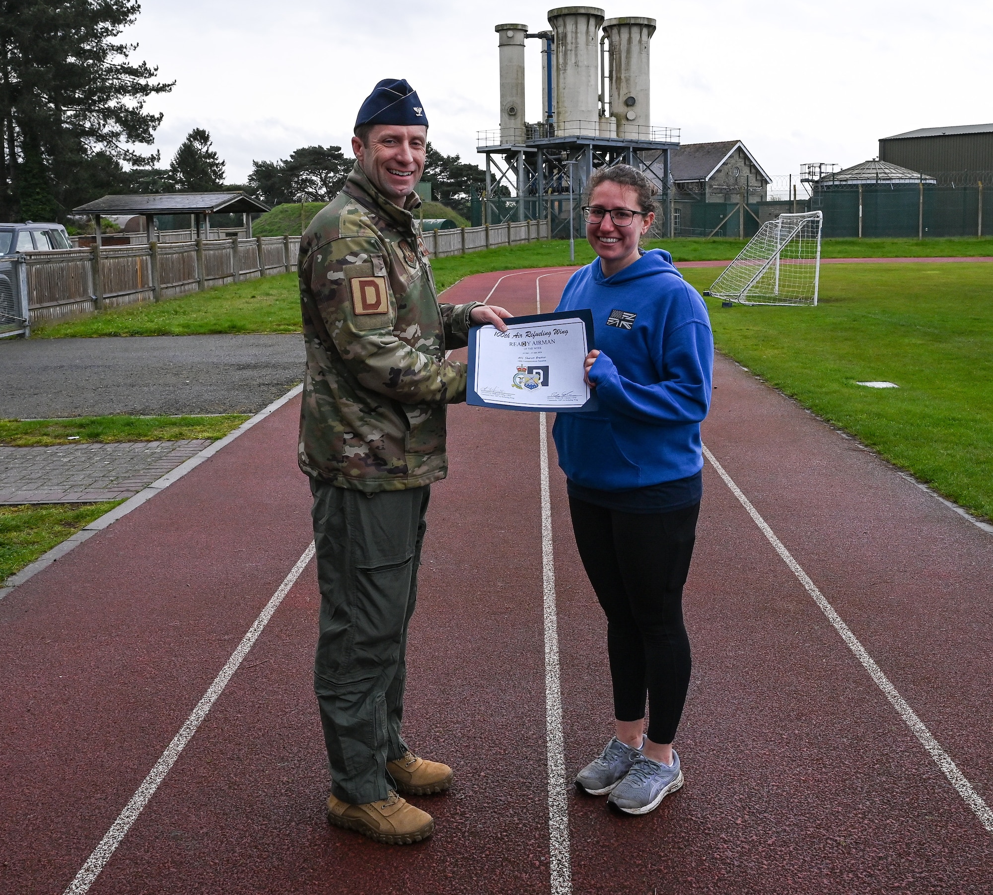 U.S. Air Force Col. Ryan Garlow, left, 100th Air Refueling Wing commander, recognizes Airman 1st Class Sharon Bremar, 100th Communications Squadron radio frequency transmission technician, as the ReaDy Airman of the Week at Royal Air Force Mildenhall, England, April 5, 2024.