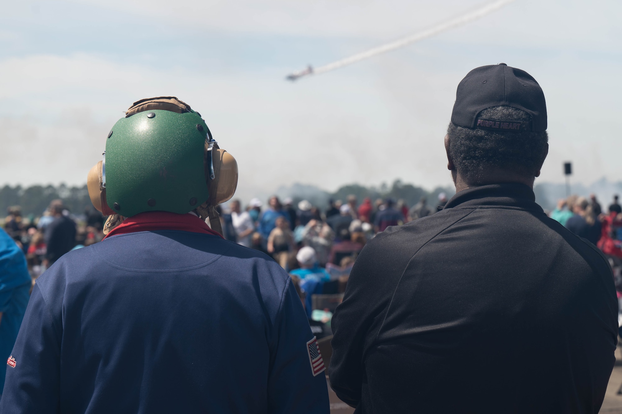 Two veterans watch as a plane descends from the sky during the Beyond the Horizon Air and Space Show at Maxwell Air Force Base, Ala. April 6, 2024. In addition to aerial performances, the event also featured ground displays of various aircraft, interactive exhibits, and opportunities for attendees to meet with pilots and aircrew members, providing a behind-the-scenes look at the technology and personnel that make air and space operations possible. (U.S. Air Force photo by A1C Tyrique Barquet)