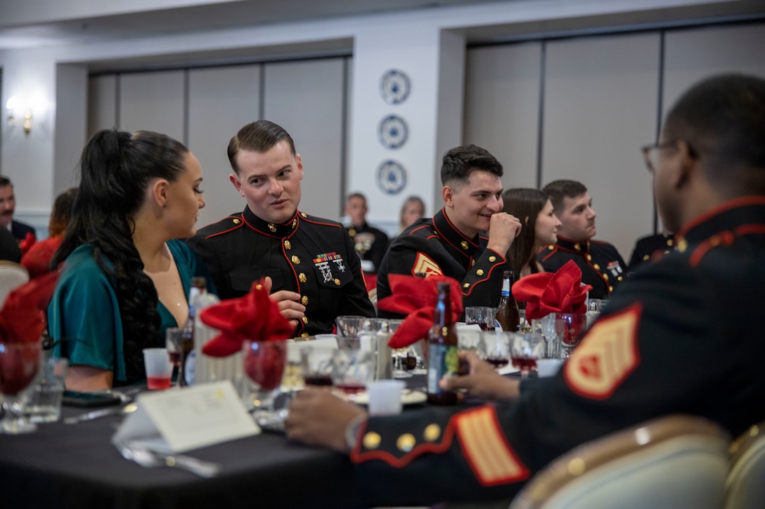 U.S. service members and families of 2nd Marine Expeditionary Brigade (2d MEB), converse during a dining out service at Marine Corps Base Camp Lejeune, North Carolina, April 3, 2024. The 2d MEB dining out was a family event to increase esprit de corps and unit morale. (U.S. Marine Corps photo by Cpl. Marc Imprevert)