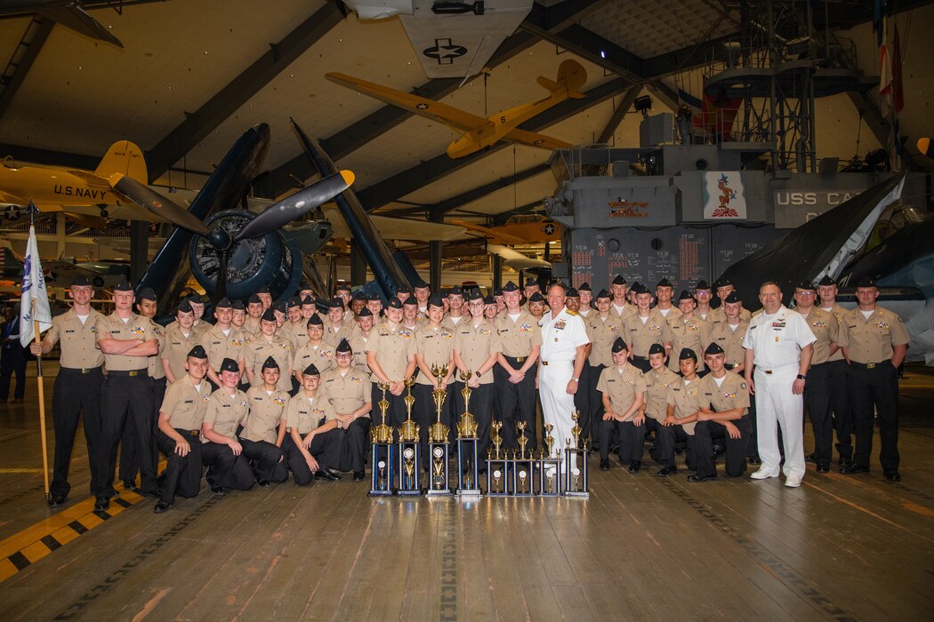 Commander, Naval Education and Training Command, Rear Adm. Jeffrey Czerewko, and Force Master Chief, NETC, Force Master Chief Rick Mengel, take a group photo with third place winner, Pace High School (Pace, Fla.) after the 2024 Navy Junior Reserve Officers Training Corps (NJROTC) National Championship awards ceremony on Naval Air Station Pensacola, Fla. The NJROTC program is under the leadership of Commander, Naval Service Training Command (NSTC) Rear Adm. Craig Mattingly and his staff, headquartered at Naval Station Great Lakes, Il. NSTC supports 98 percent of officer and enlisted initial accessions training. NSTC’s support includes Recruit Training Command at Naval Station Great Lakes, Ill., the Naval ROTC program at more than 160 colleges and universities, Officer Training Command at Newport, R.I., and NJROTC Navy National Defense Cadet Corps citizenship development programs at nearly 600 high schools worldwide.