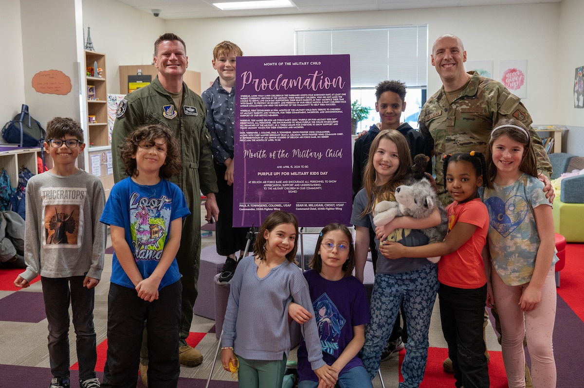 U.S. Air Force Col. Paul Townsend, left, 354th Fighter Wing commander, and Chief Master Sgt. Sean Milligan, 354th FW command chief, and military children pose for a group photo with this year’s signed Month of the Military Child proclamation at Eielson Air Force Base, Alaska, April 5, 2024.