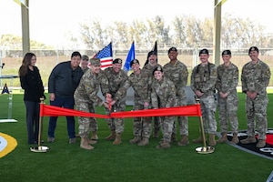 Vandenberg members assist in cutting a red ribbon for the new Military Working Dog facility.