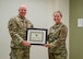 Maj. Gen. Thomas Harrell, 59th Medical Wing commander, presents Col. Wendi Wohltmann, 59th Medical Specialty Squadron dermatopathologist and dermatologist, with the Military Health System 2023 Award for the Advancement of Women Physicians in Military Medicine at Wilford Hall Ambulatory Surgical Center, Joint Base San Antonio-Lackland, Texas, Feb. 7, 2024. The award honors individuals for their efforts in advocating for, mentoring, and leading initiatives that empower and support women physicians across different aspects of their careers, such as education, training, research, and leadership growth. (U.S. Air Force photo by Senior Airman Melody Bordeaux)