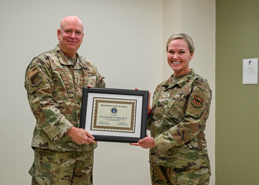 Maj. Gen. Thomas Harrell, 59th Medical Wing commander, presents Col. Wendi Wohltmann, 59th Medical Specialty Squadron dermatopathologist and dermatologist, with the Military Health System 2023 Award for the Advancement of Women Physicians in Military Medicine at Wilford Hall Ambulatory Surgical Center, Joint Base San Antonio-Lackland, Texas, Feb. 7, 2024. The award honors individuals for their efforts in advocating for, mentoring, and leading initiatives that empower and support women physicians across different aspects of their careers, such as education, training, research, and leadership growth. (U.S. Air Force photo by Senior Airman Melody Bordeaux)