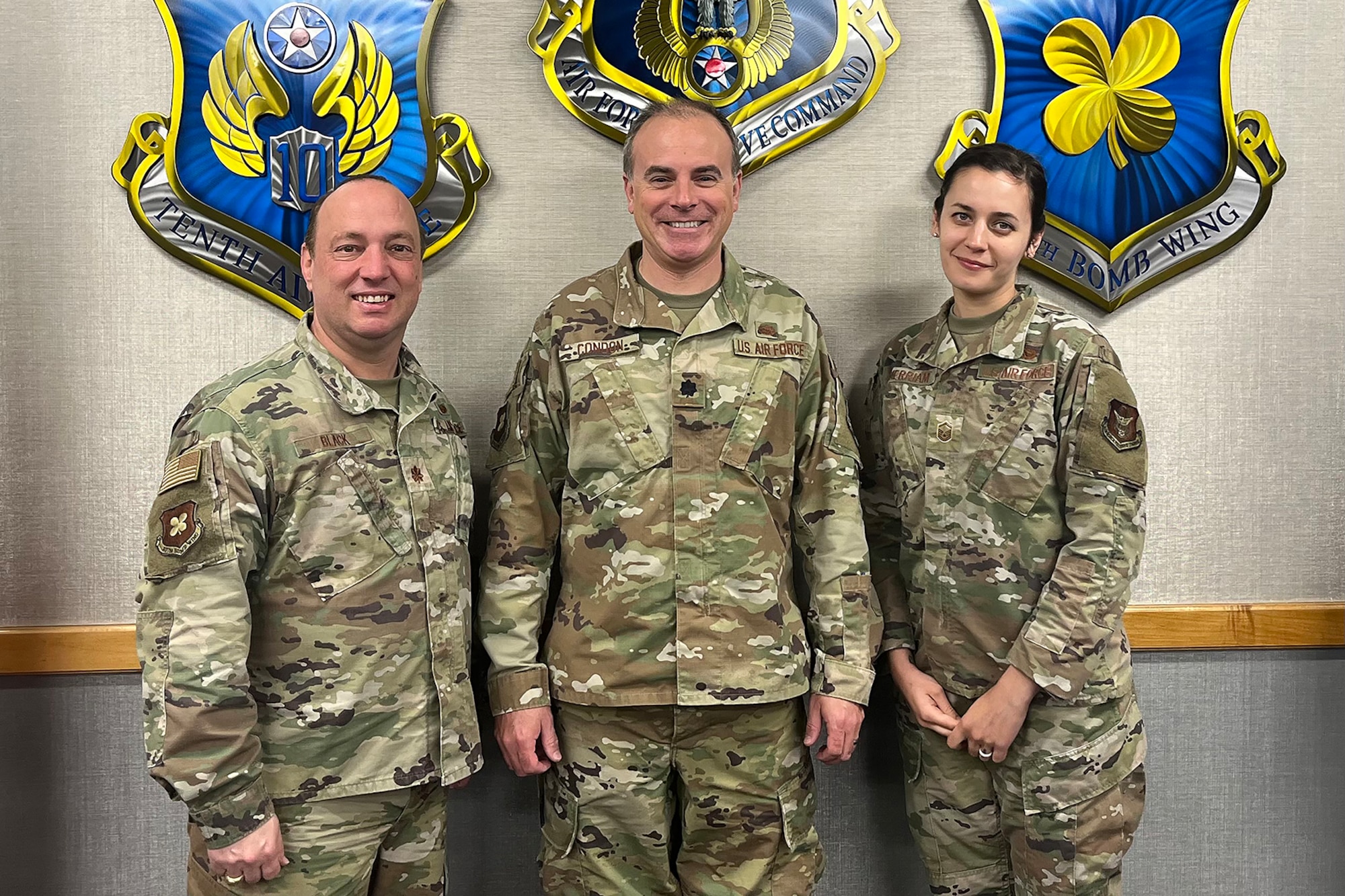 Three smiling Airmen pose for photo