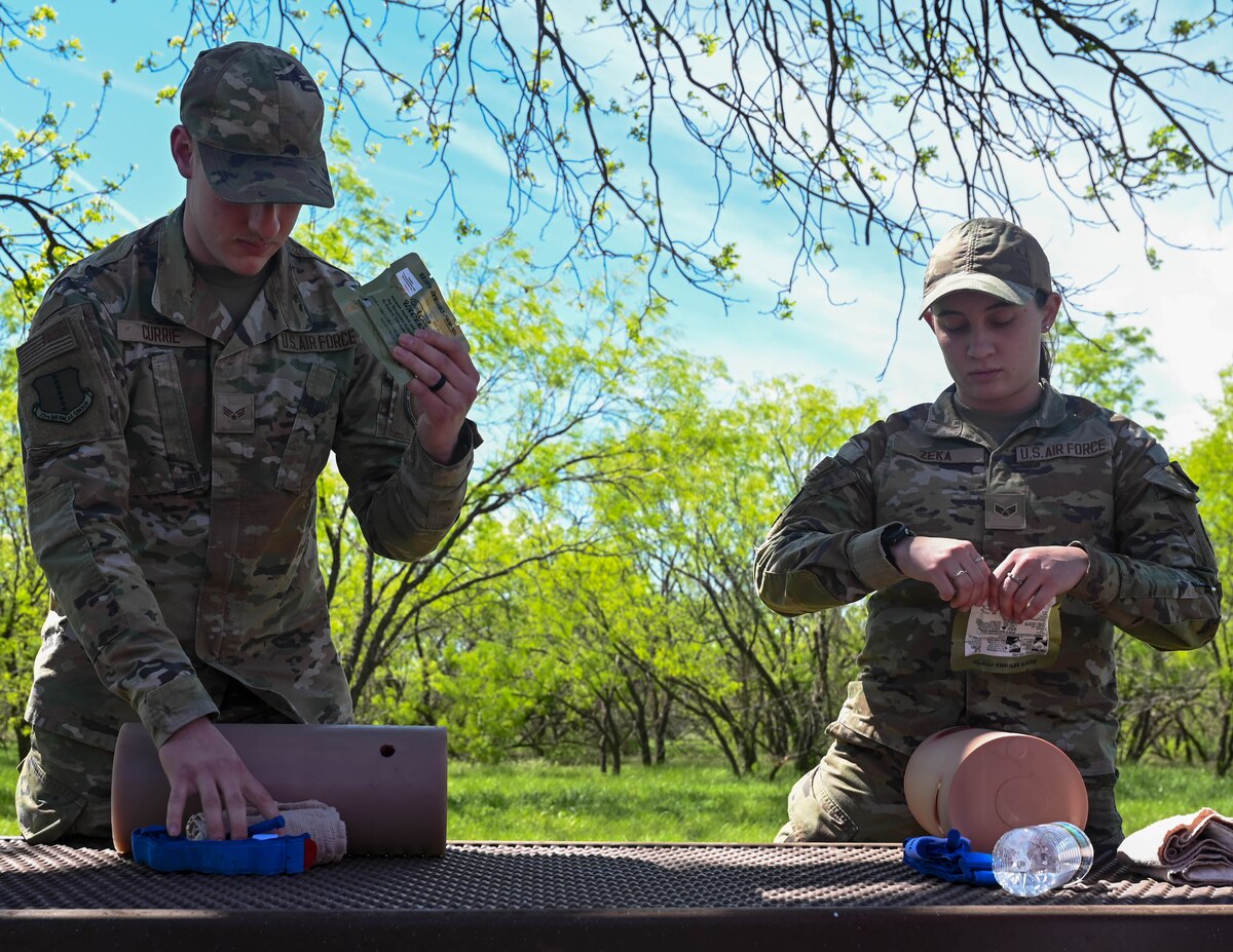 U.S. Senior Airmen Christian Currie and Vanesa Zeka, 17th Operational Medical Readiness Squadron aerospace medical technicians, teach Tactical Combat Casualty Care to the 17th Training Wing honorary commanders at Goodfellow Air Force Base, Texas, April 5, 2024. TCCC teaches life-saving techniques and strategies for providing the best trauma care on the battlefield. (U.S. Air Force photo by Senior Airman Zach Heimbuch)
