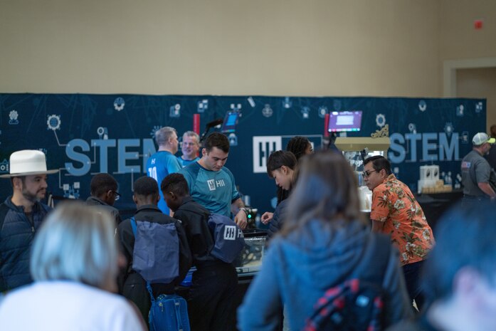 Attendees enter the main exhibit area for the Sea-Air-Space Science, Technology, Engineering, and Math (STEM) expo at the Gaylord National Hotel and Conference Center, Sunday. Conference goers had the opportunity to participate in hands-on science activities and experience interactive exhibits based on STEM concepts with more than 20 exhibitors from various Department of Defense service branches.