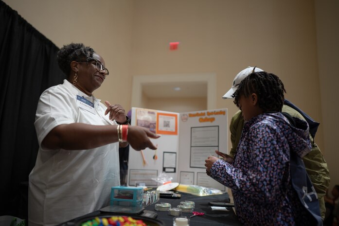 Robin Houston (left), the founder and director of FIRE Rocket Challenge, talks to students about the concepts of building, modifying, and launching rockets during the Sea-Air-Space Science, Technology, Engineering, and Math (STEM) expo at the Gaylord National Hotel and Conference Center, Sunday. Participants had the opportunity to launch their miniature rockets at targets to test design and mechanics. FIRE Rocket Challenge provides STEM education programming to traditionally underrepresented and under-resourced youth. FIRE Rocket partnered with the U.S. Navy's Strategic Systems Programs (SSP) to connect STEM activities to elements of the real-world missions of commands like SSP.  SSP is the Navy command that is responsible for the cradle-to-grave lifecycle of the submarine-launched ballistic missile system.