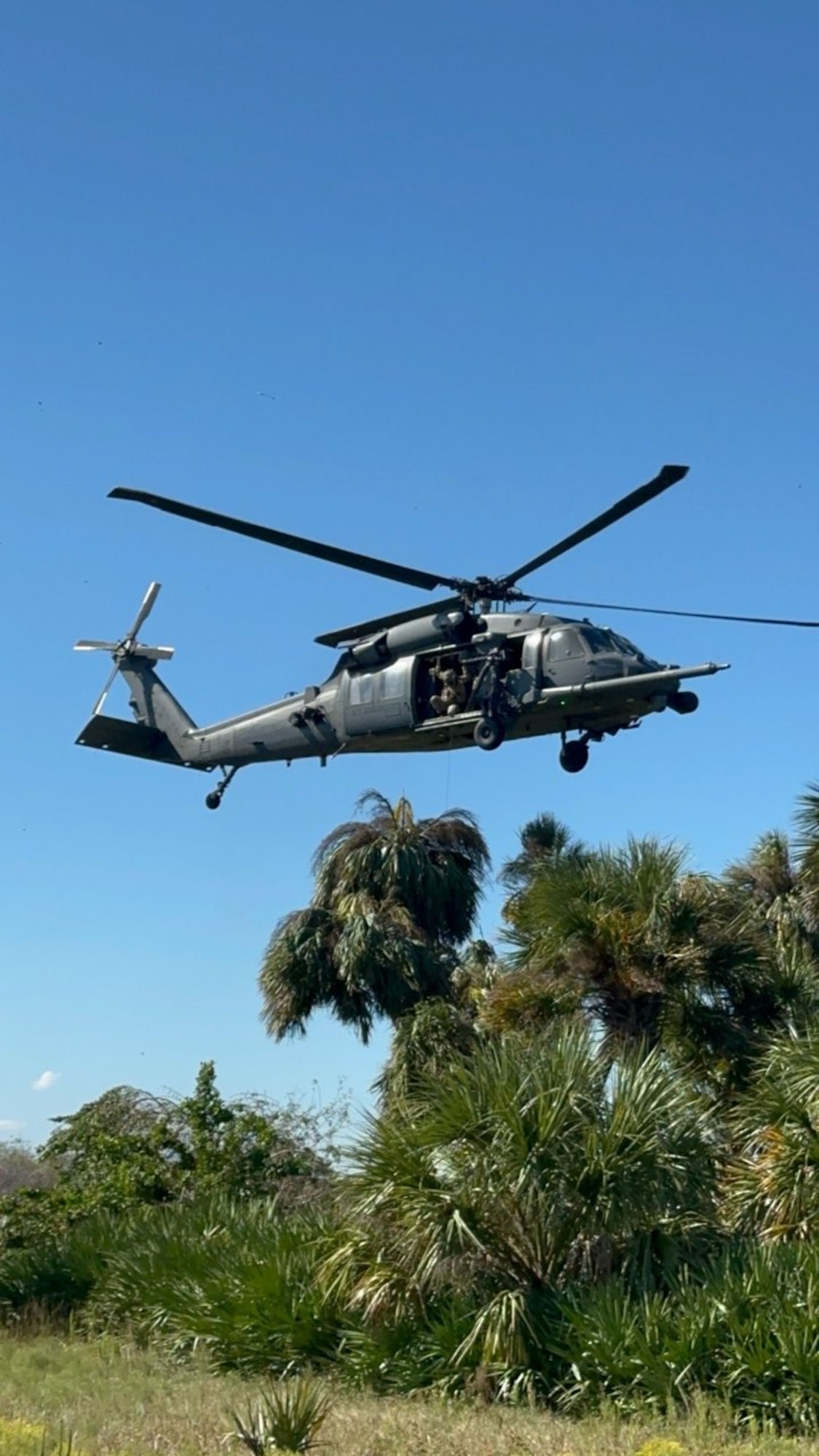 Special Missions Aviators inside an HH-60G Pave Hawk helicopter search for a simulated isolated person during a skills-based competition event at Avon Park Air Force Range, Florida, Nov. 7, 2023. This skills-based competition brings together combat search and rescue squadrons from around the world, offering valuable training and skill development as participants learn from each other's techniques, tactics and experiences. (U.S. Air Force Courtesy Photo)