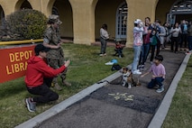 U.S. Marine Corps Pfc. Bruno, the Marine Corps Recruit Depot San Diego and the Western Recruiting Region Mascot, greets guests of an eclipse watch party at the MCRD San Diego library, MCRD San Diego, California, April 8, 2024. The mascot's job is to boost morale, participate in outreach work and attend events and ceremonies. (U.S. Marine Corps photo by Sgt. Jesse K. Carter-Powell)