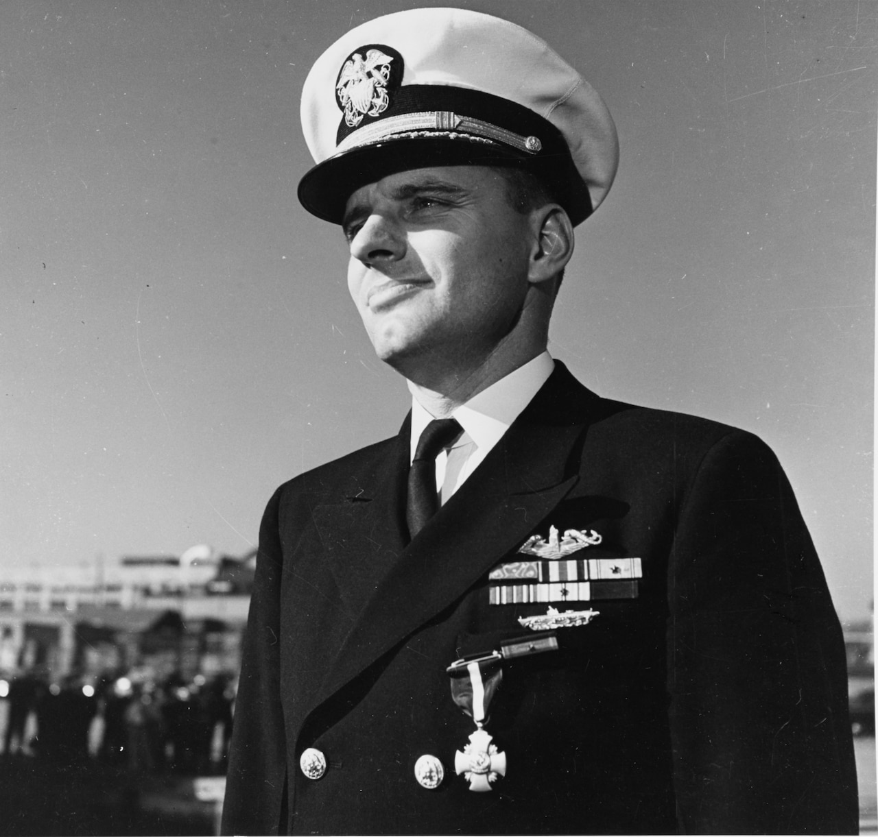 A man in dress uniform looks into the distance.