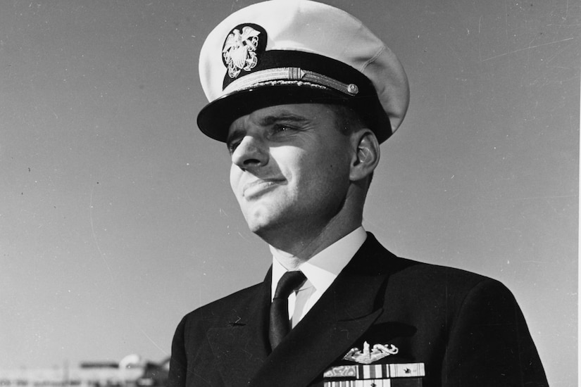 A man in dress uniform looks into the distance.