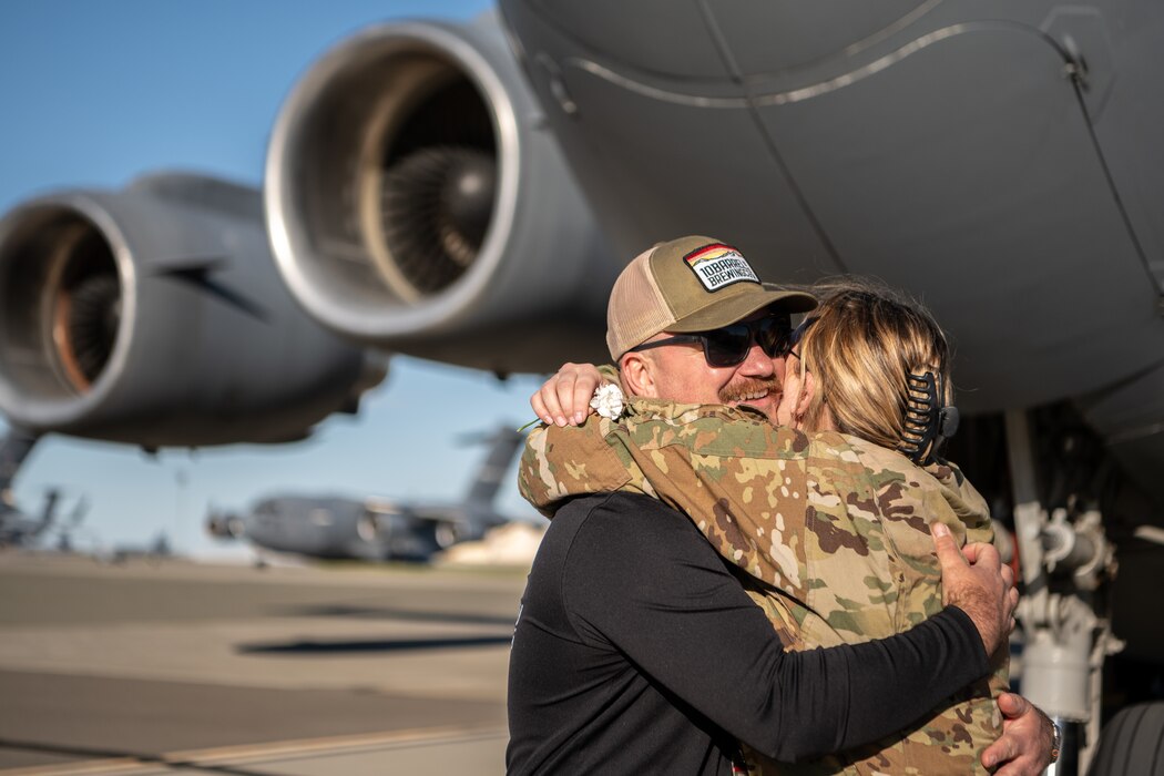 An Airmen hugs her husband after returning from a deployment