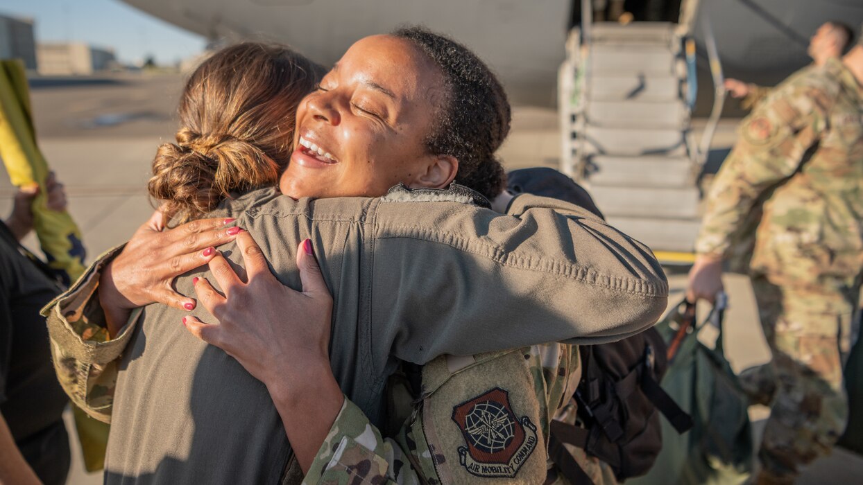 An Airmen hugs another Airmen after returning from a deployment