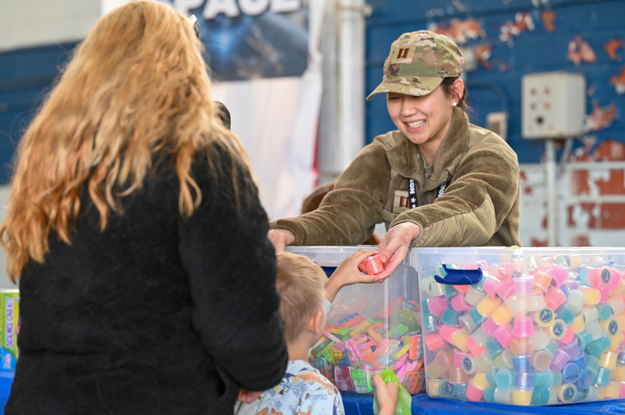 U.S. Air Force Capt. Lynn Phu, assigned to the 42nd Medical Group, hands out toys during the Beyond the Horizon Air and Space Show at Maxwell Air Force Base, Ala. April 7, 2024. The air and space show boasted a variety of activities, including military and civilian aerial demonstrations, static display aircraft, and a STEM expo. (U.S. Air Force photo by Senior Airman Evan Porter)