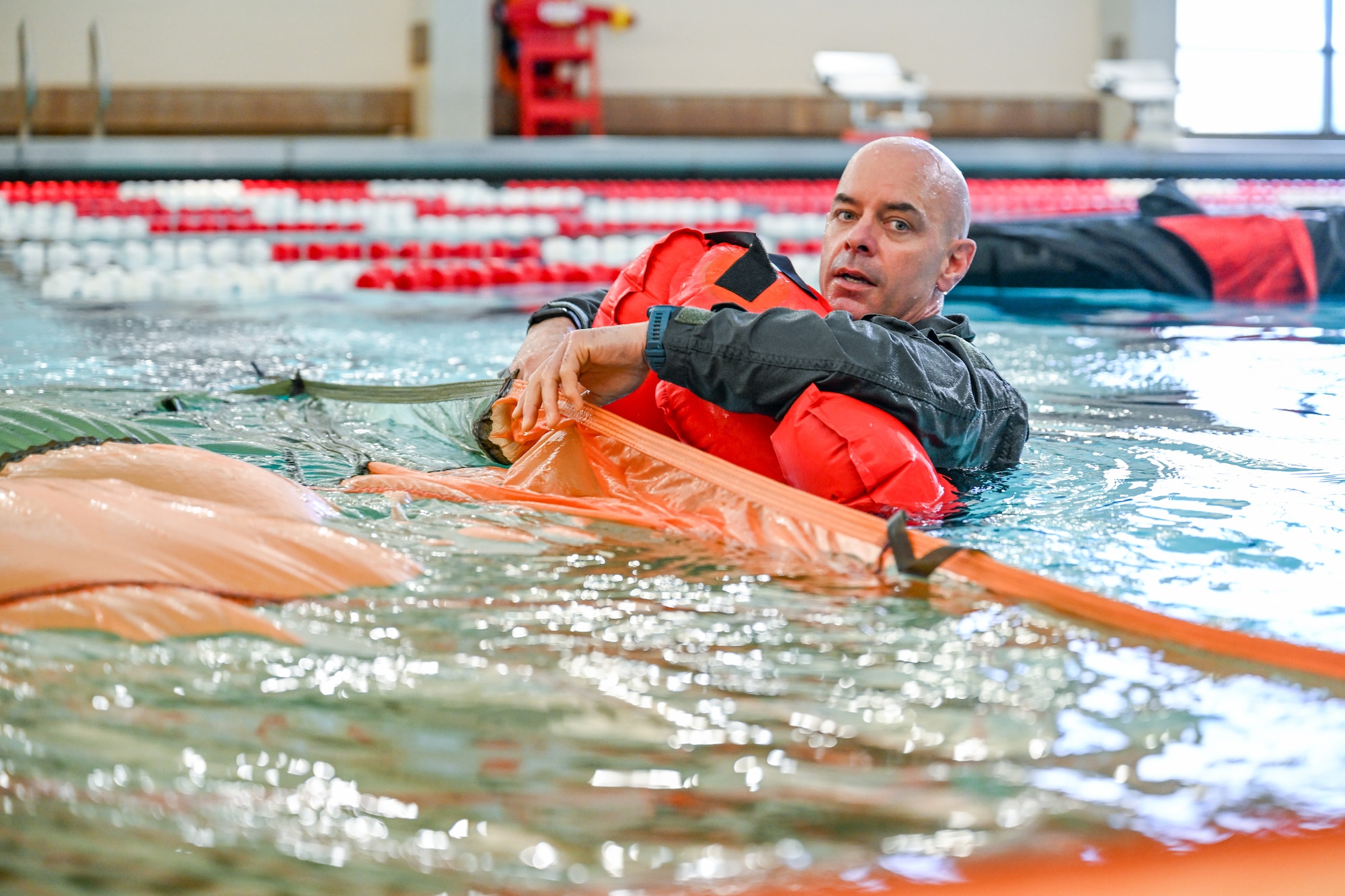 Lt. Col. Frank Galati, a flight safety officer with the 910th Airlift Wing, emerges from underneath a parachute during water survival training on April 7, 2024, at Youngstown State University, Ohio.